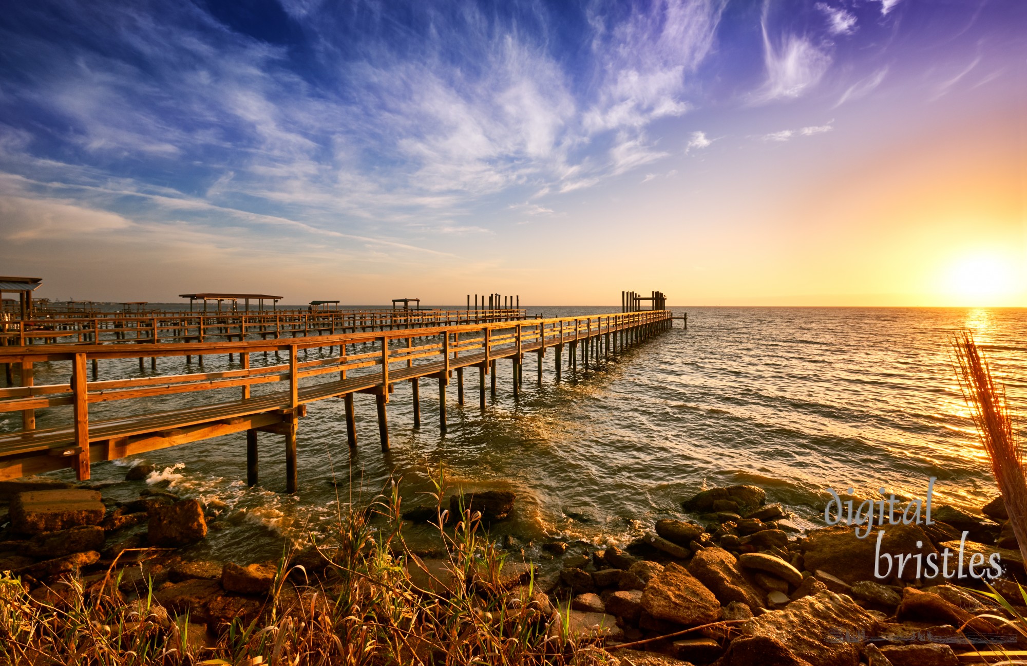 Long wooden docks reach into Galveston Bay, Texas, at sunrise