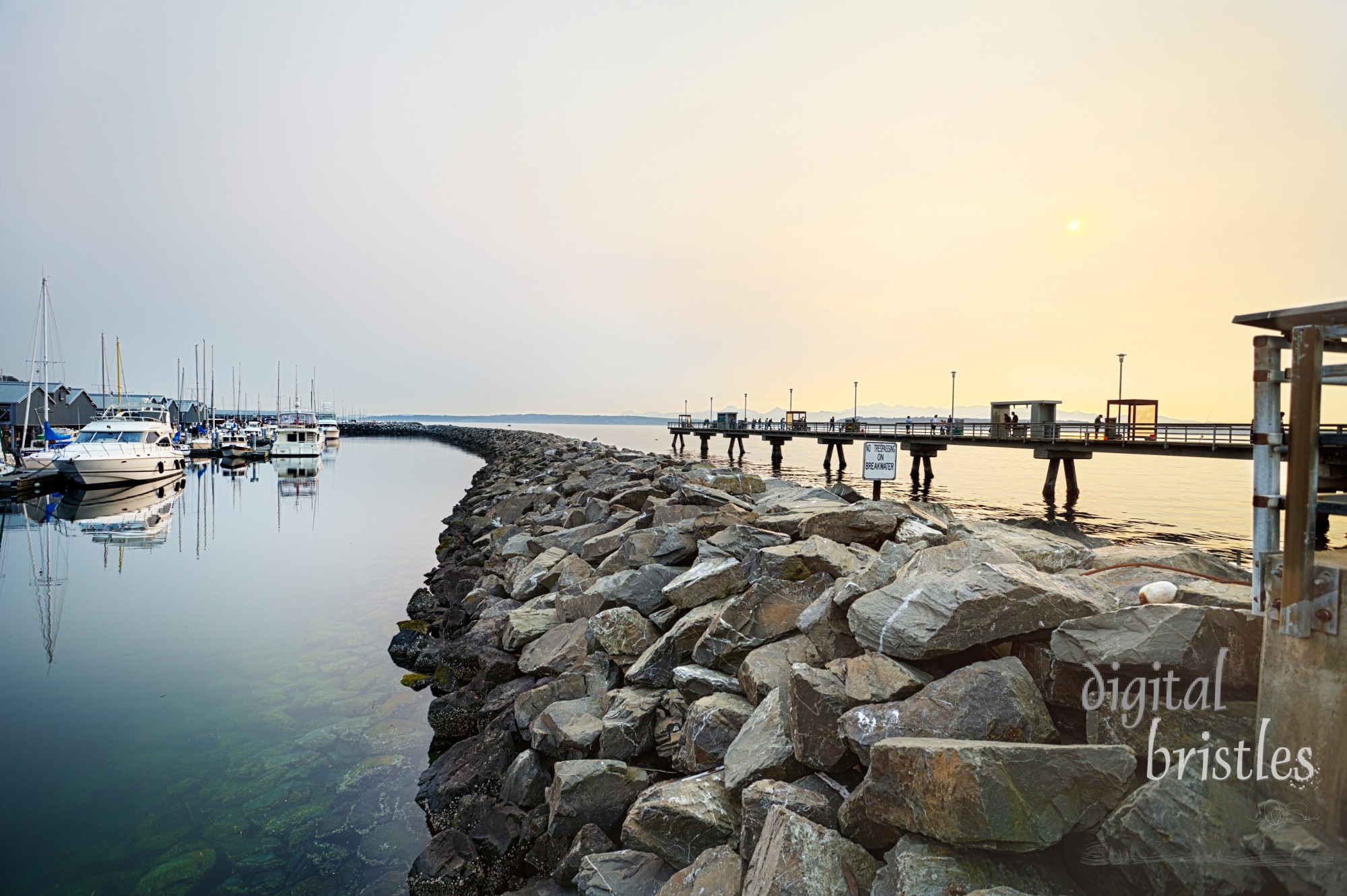 Hazy summer sun going down over the pier in Edmonds