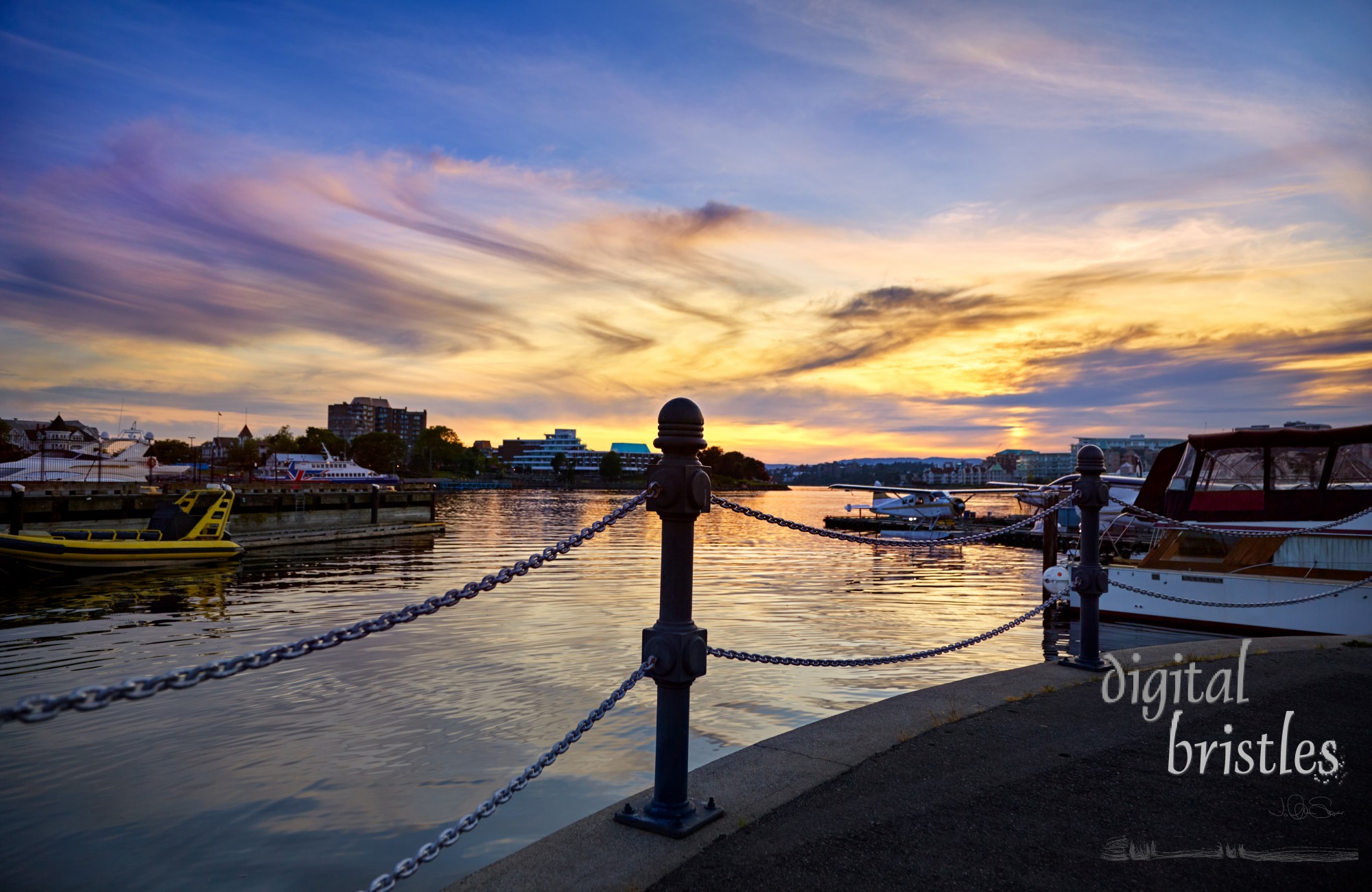 Sun goes down over boats and planes in Victoria, British Columbia's, inner harbor