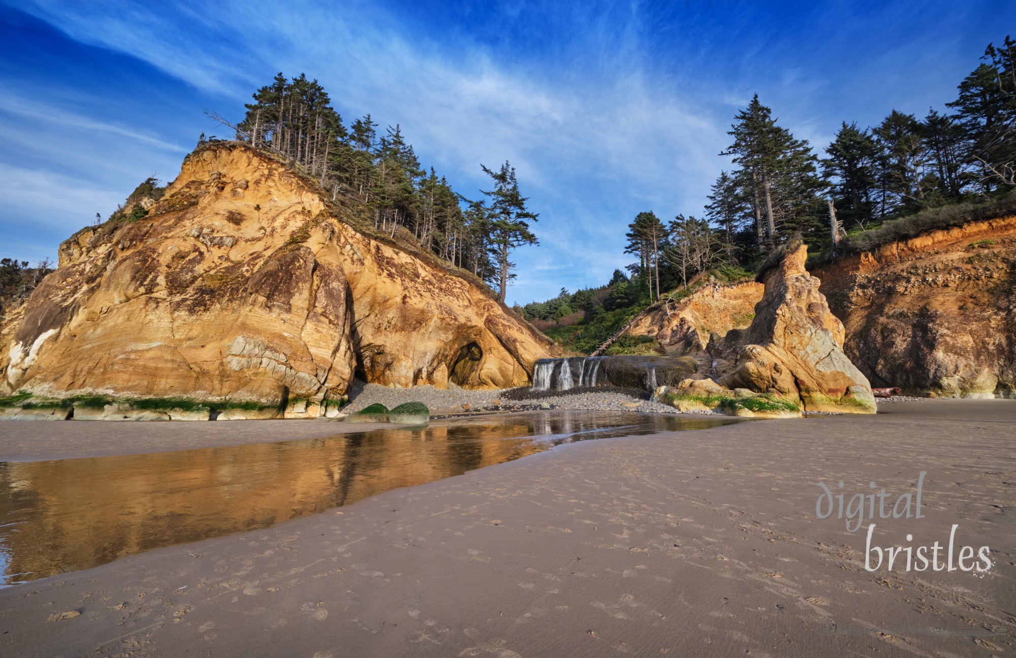 Hug Point State Recreation Area at low tide. Caves eroded by the waves and a waterfall add to the natural beauty