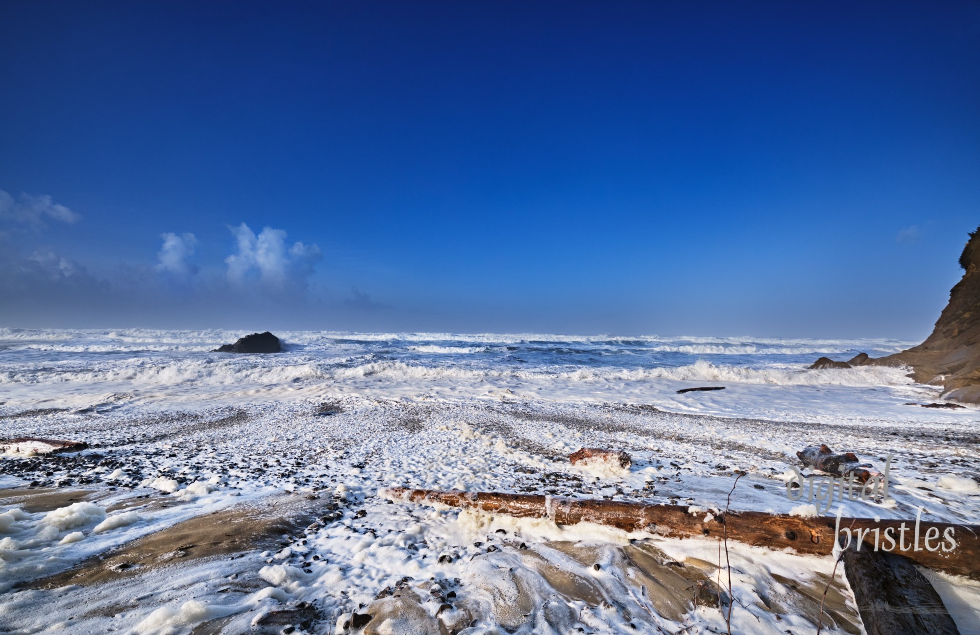 Winter high tide tosses huge logs around on the beach at Arch Cape, Oregon