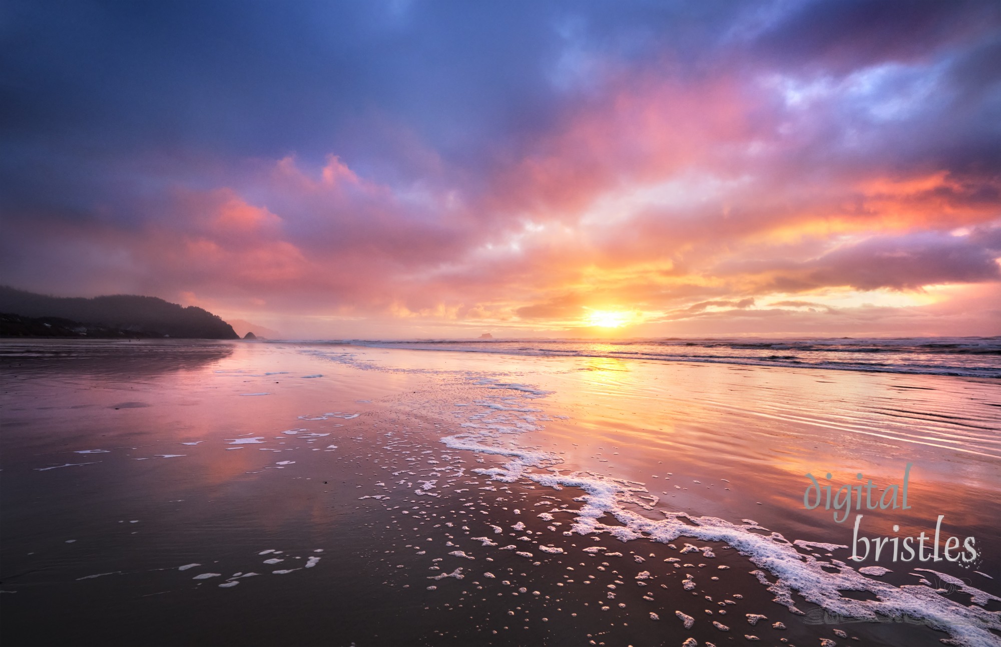 A Wintry beach in Arch Cape, Oregon with the sun going down at low tide