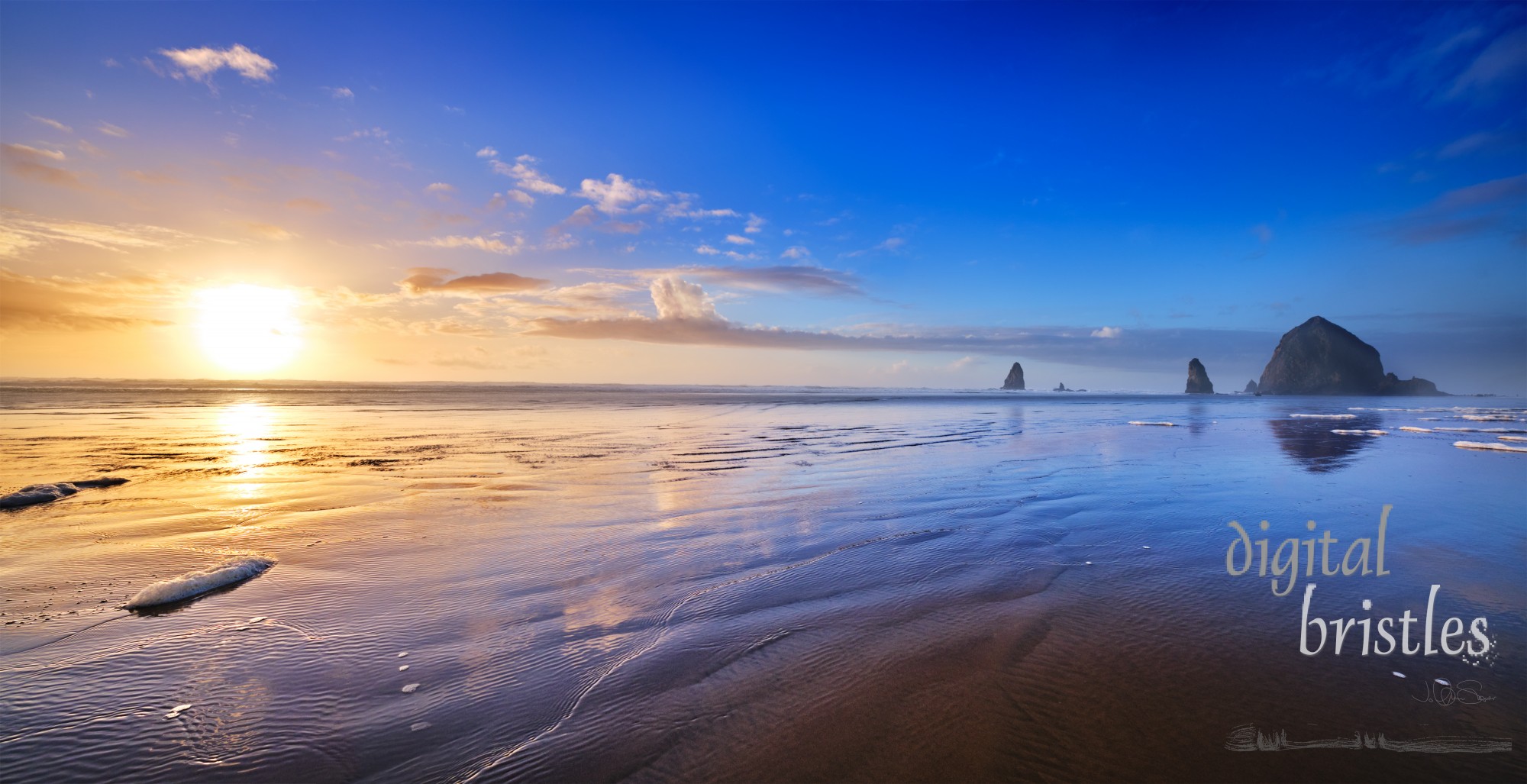 The wide flat sands of Cannon Beach reflect the clouds as iconic Haystack Rock and the Needles frame a serene Winter sunset