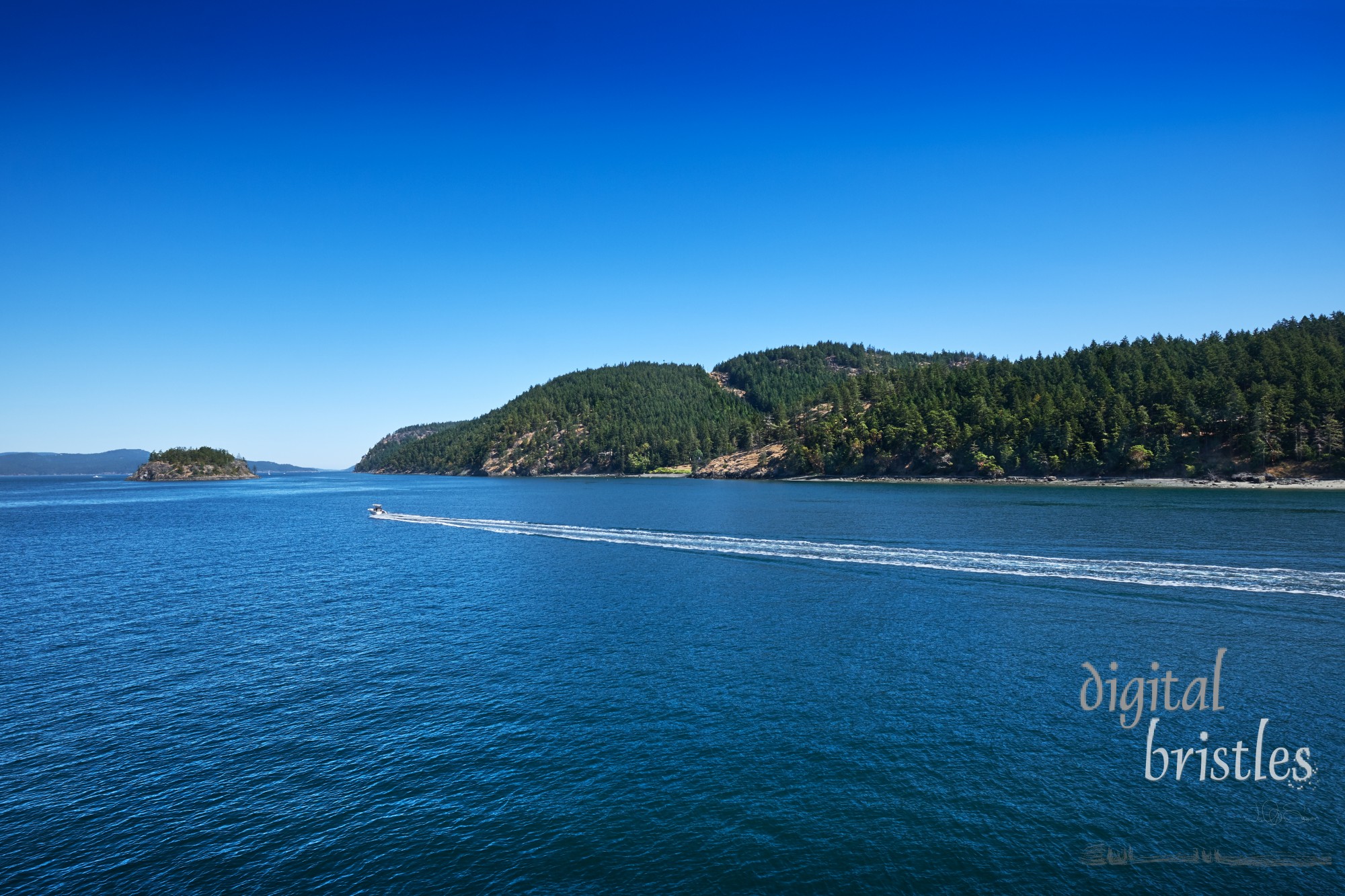 Speedboat threads its way Westward through the San Juan Islands on a sunny summer day