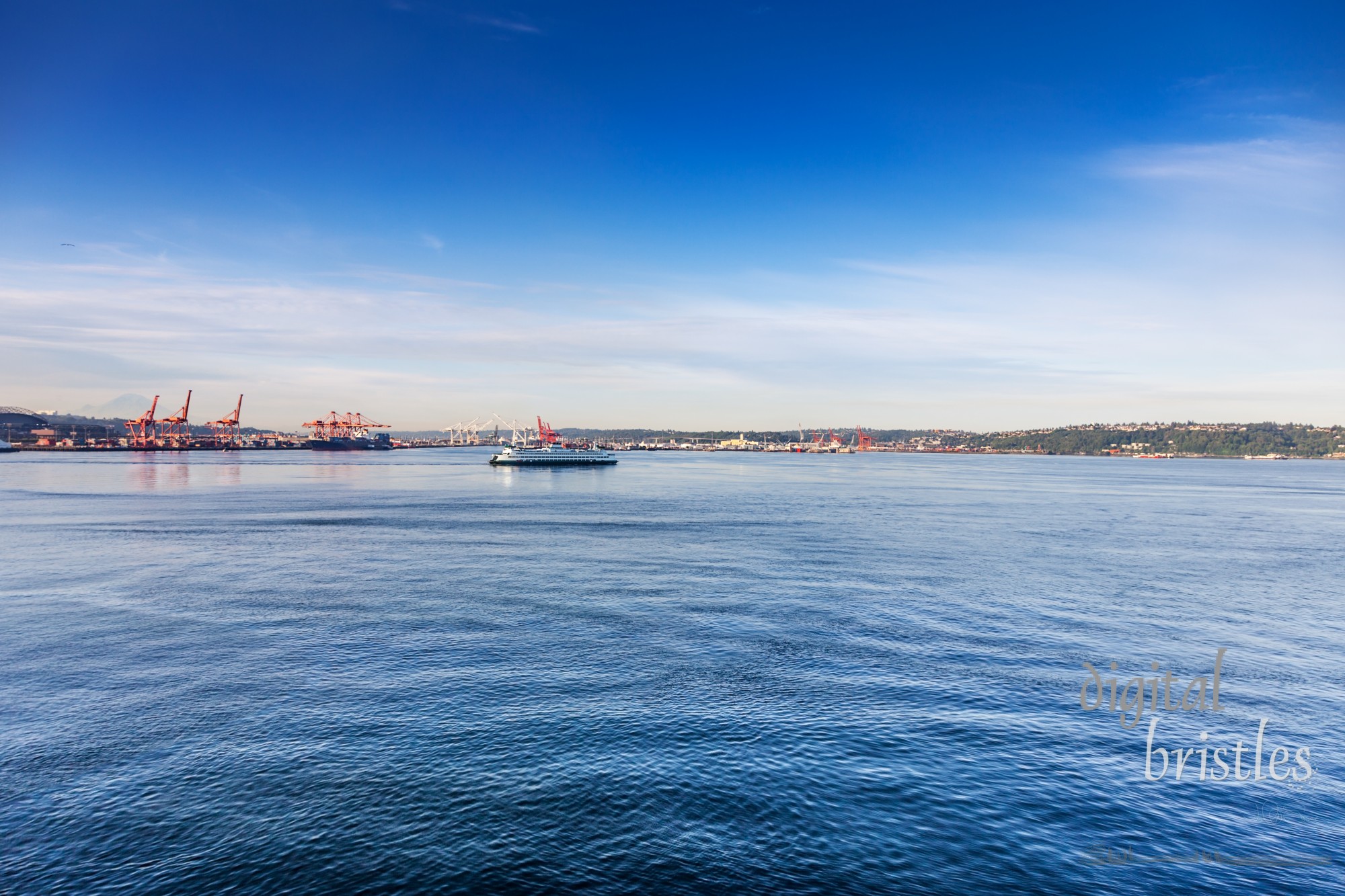 Washington State Ferry crosses Elliot Bay on a route from Seattle to Bainbridge Island. Port of Seattle in the background