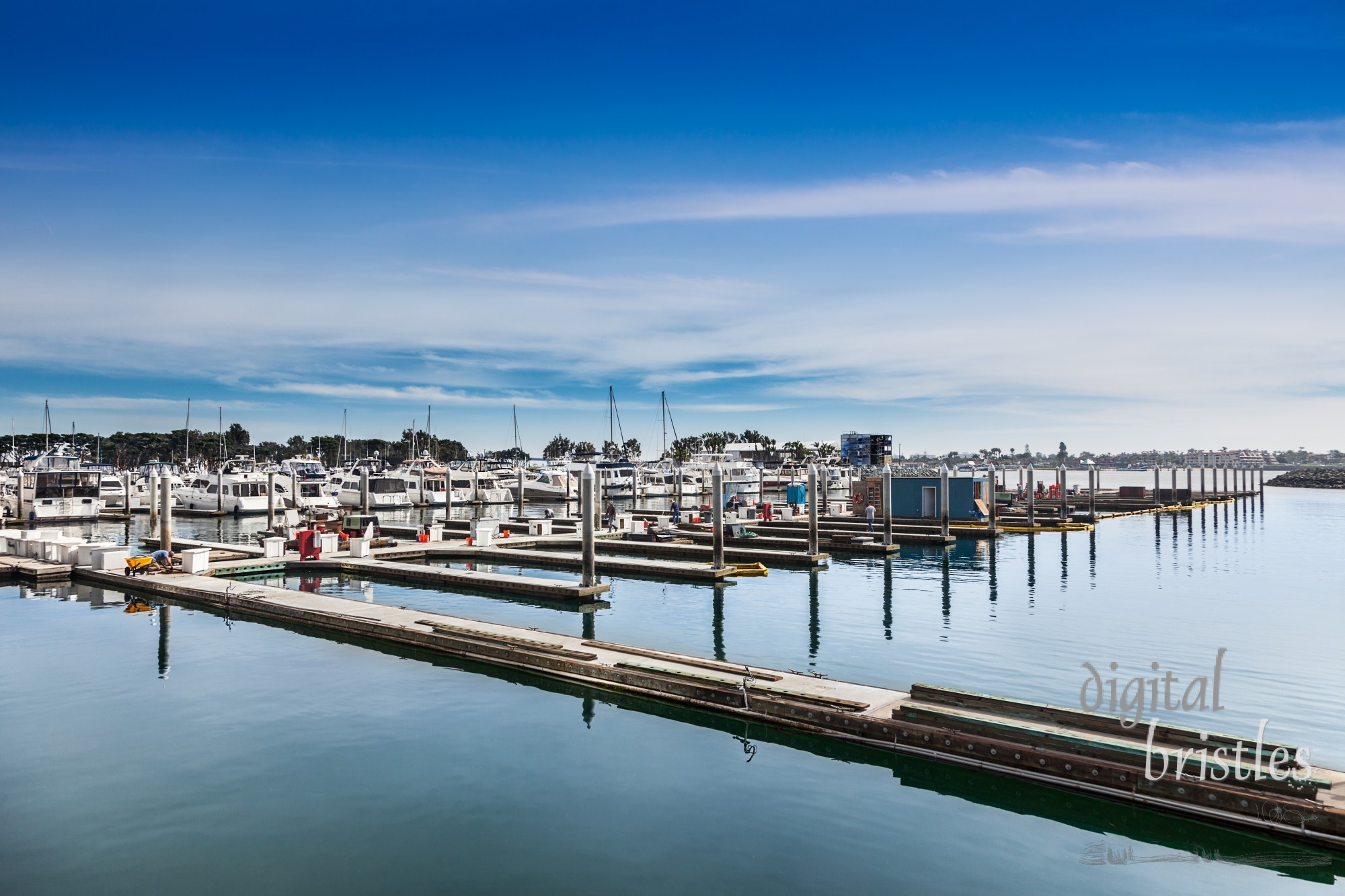 Workers rebuilding boat slips at the San Diego Embarcadero Marina. San Diego Bay and Coronado in the background