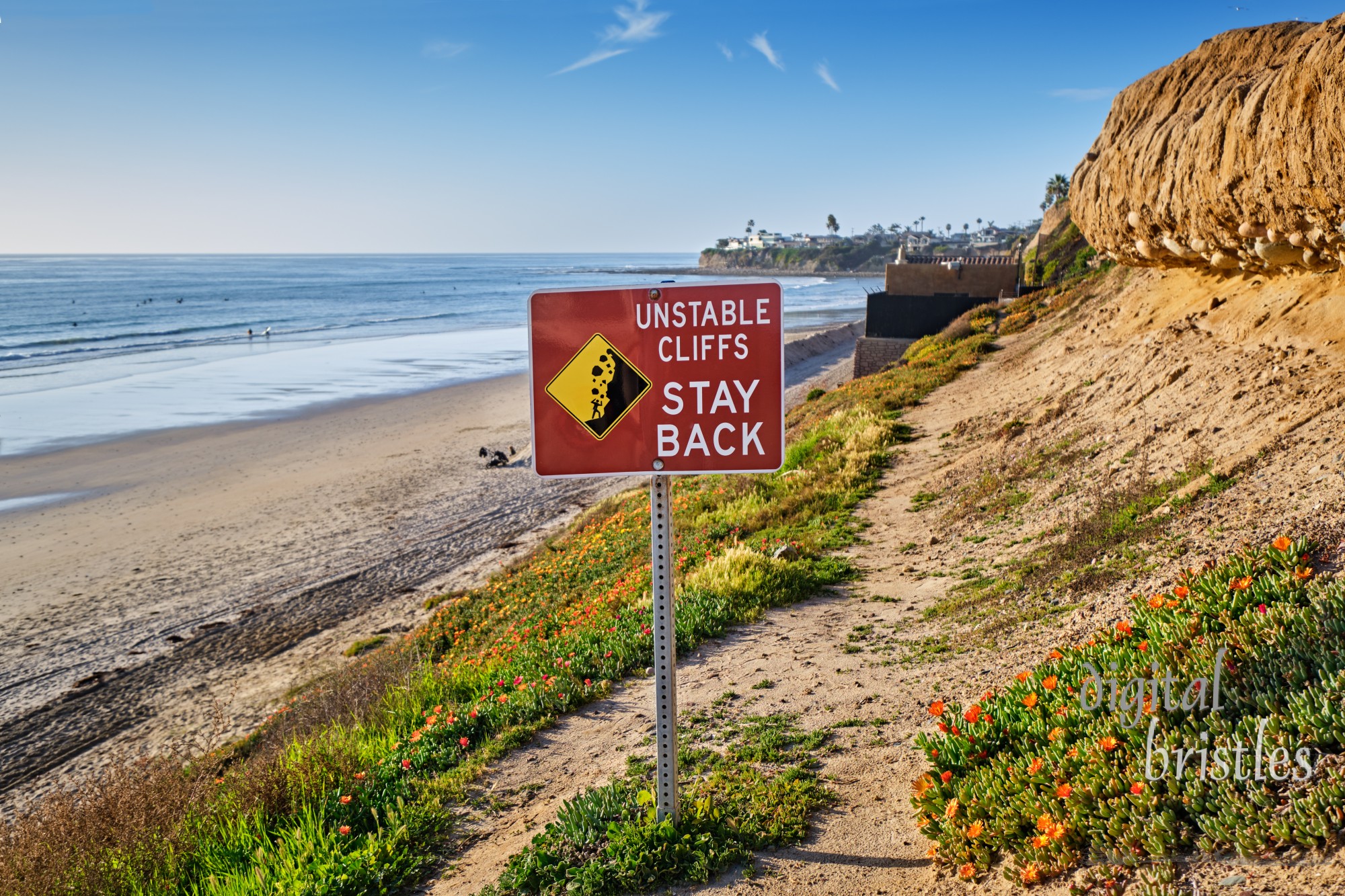 Sign warns that the cliffs behind Pacific Beach, California are not stable