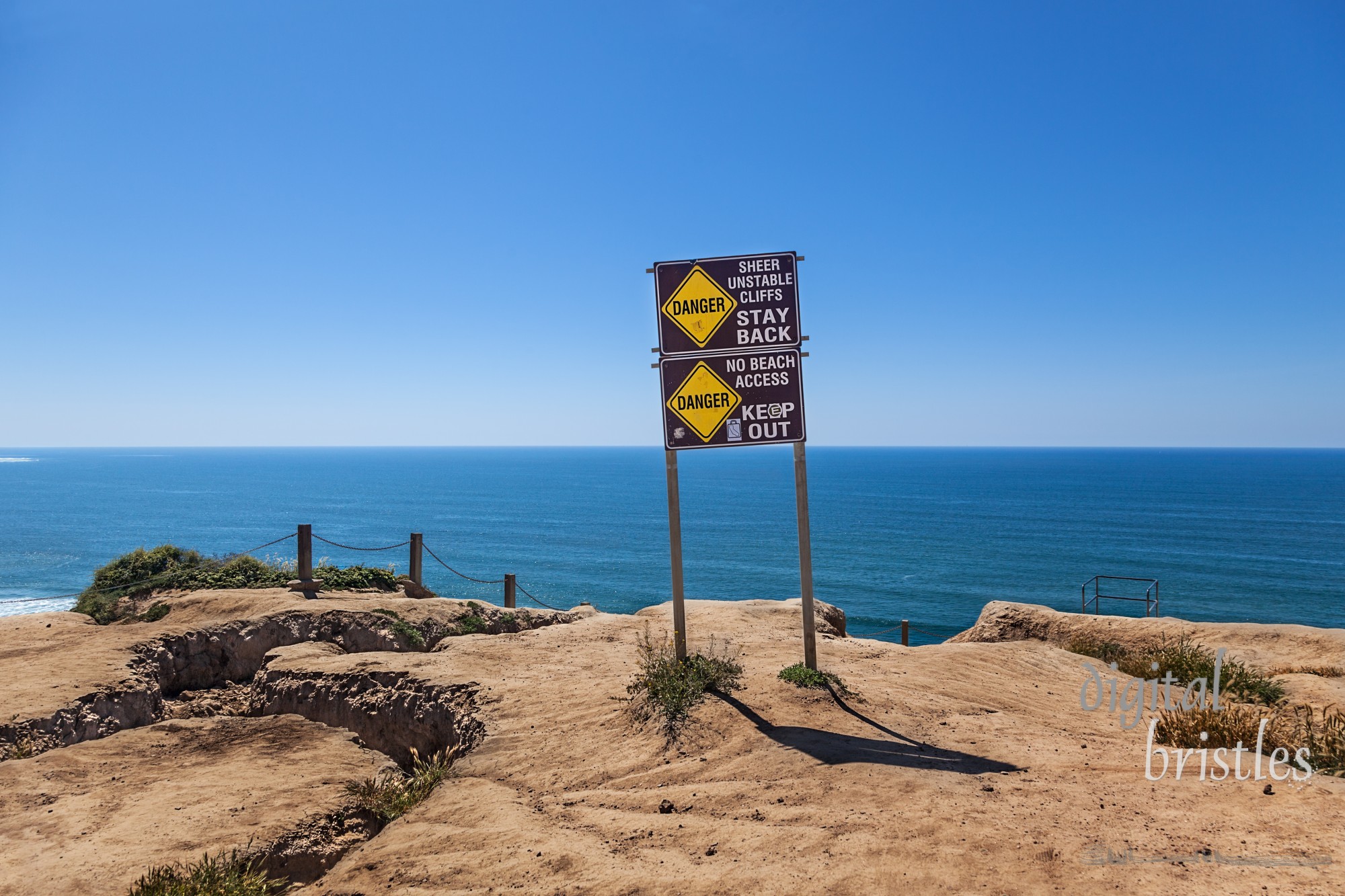 Signs warning about eroded unstable cliffs near Torrey Pines Gliderport just north of San Diego, California