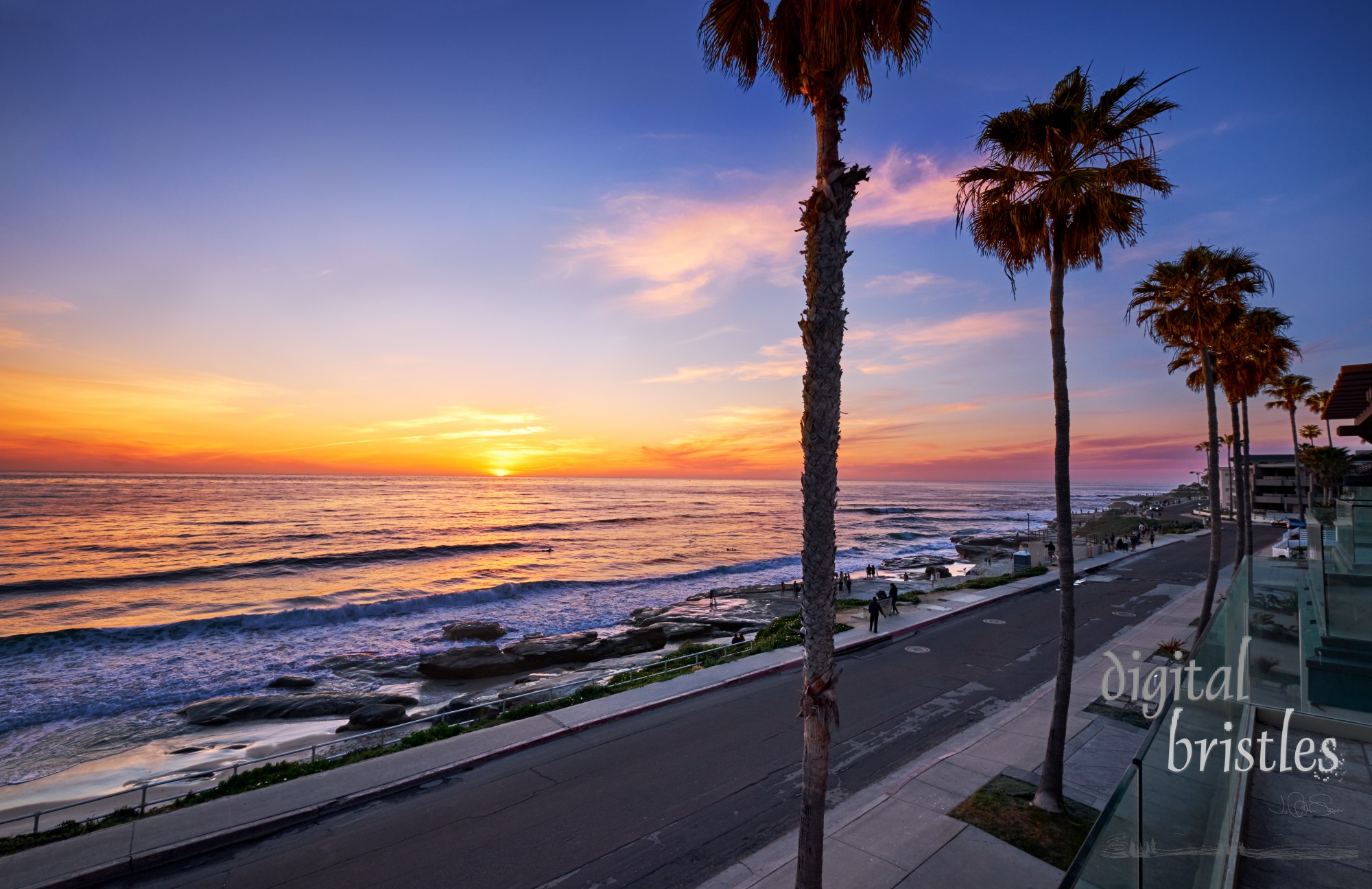 People stop to watch the sun dip below the horizon at Windansea Beach, San Diego