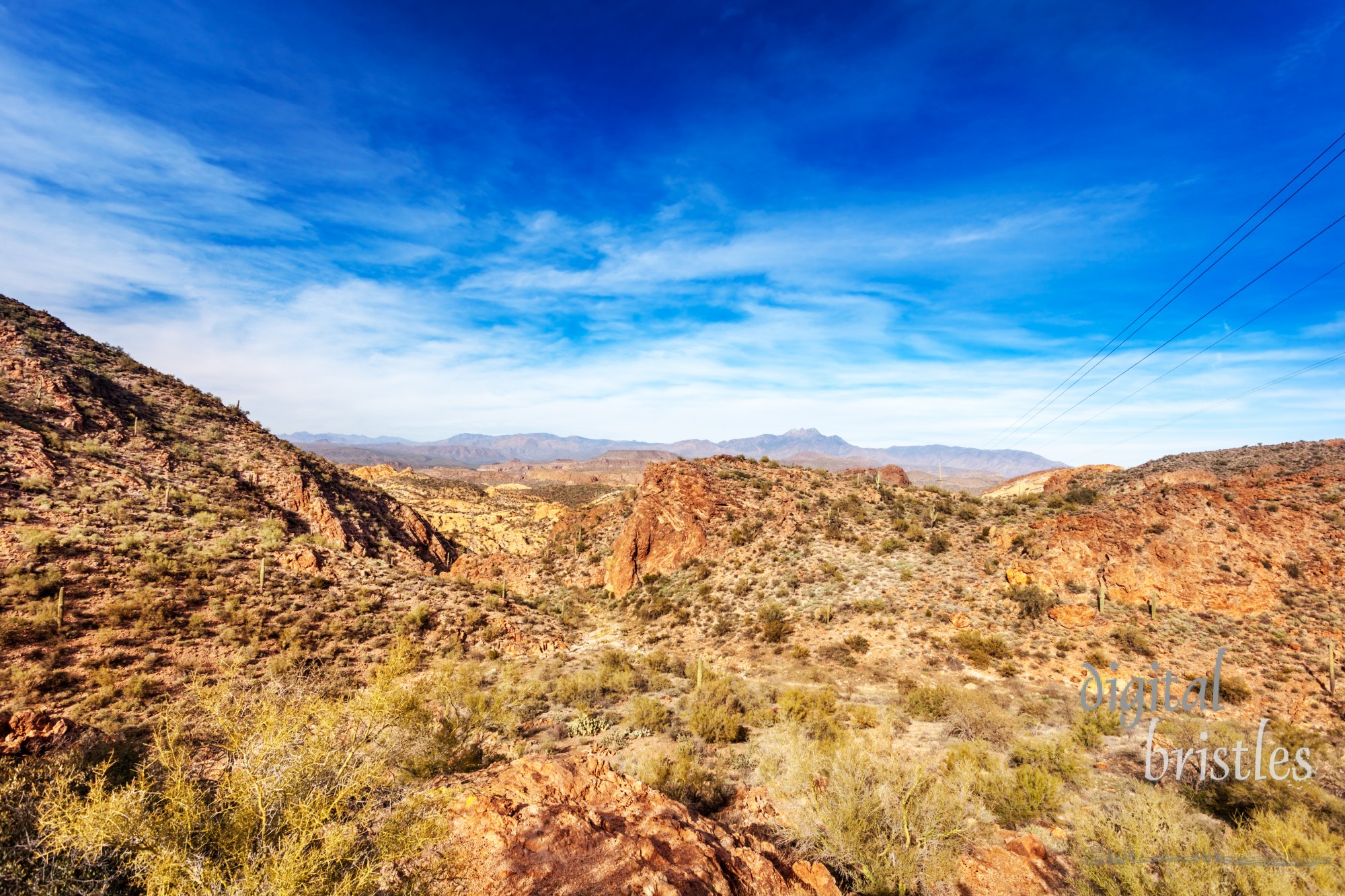 Four Peaks Mountains in the distance behind the red rocky landscape running by the Apache Trail through the Tonto National Forest Arizona