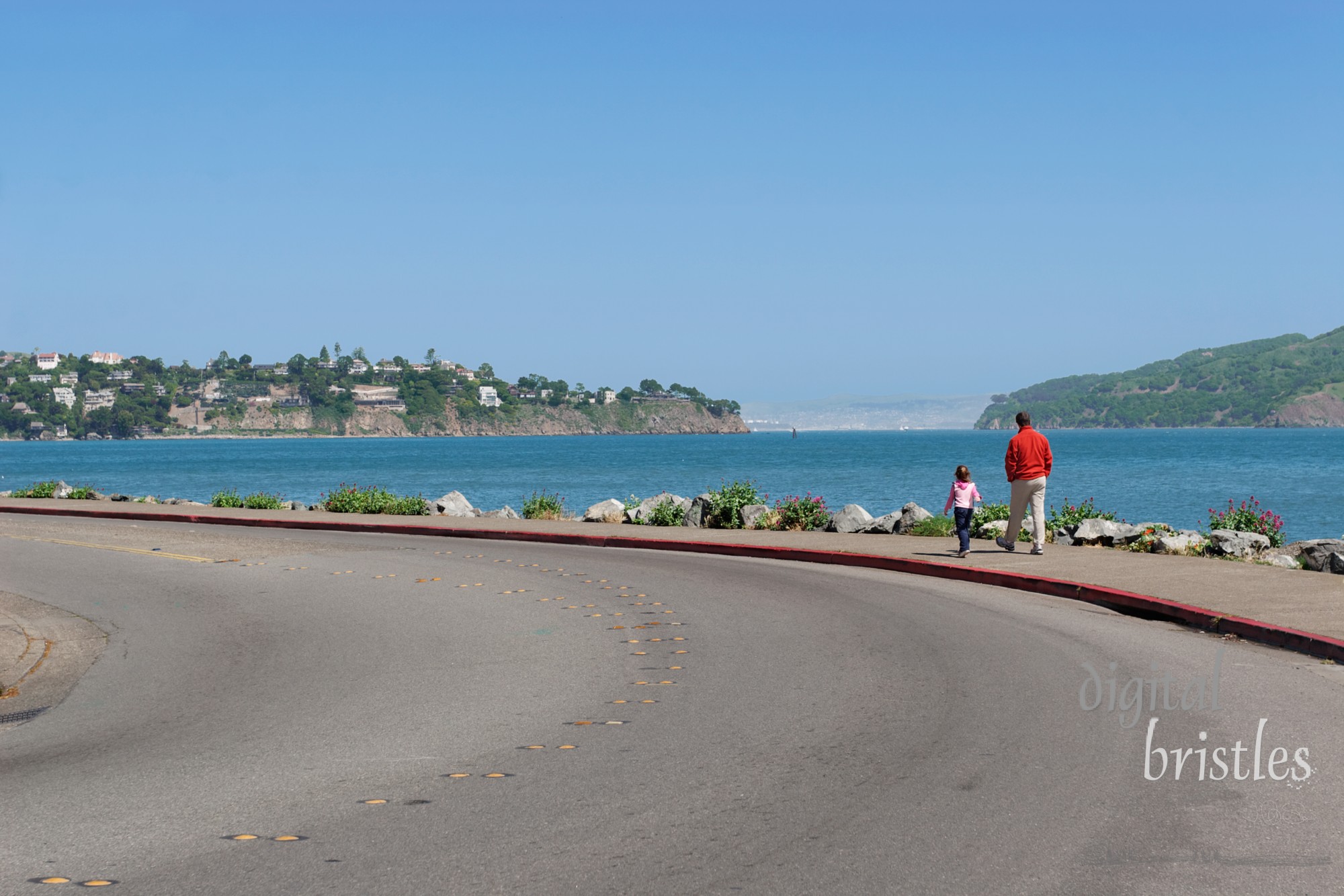 A man and his daughter stroll beside the bay in Sausolito, California