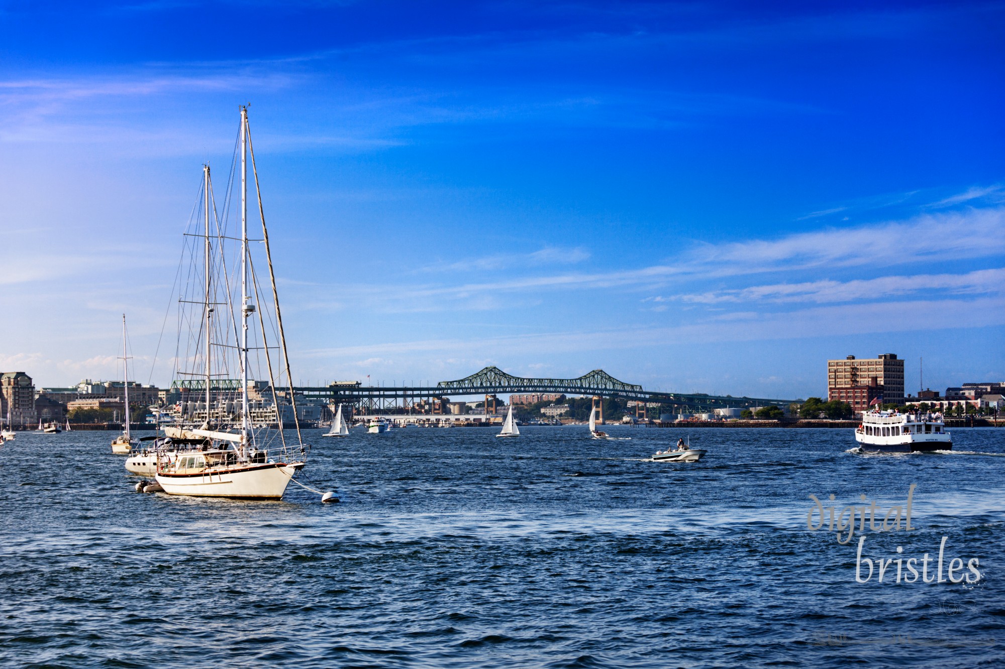 Boats in busy Boston Harbor with the Tobin Bridge in the background