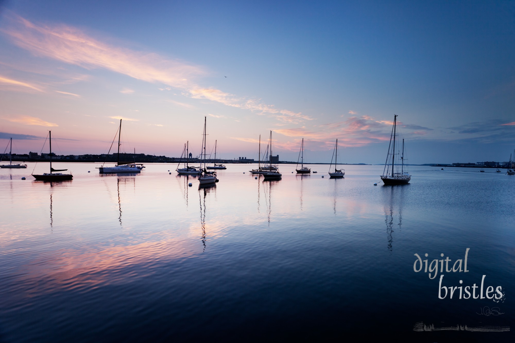 Pinks and blues of sunrise sky over boats in Boston Harbor