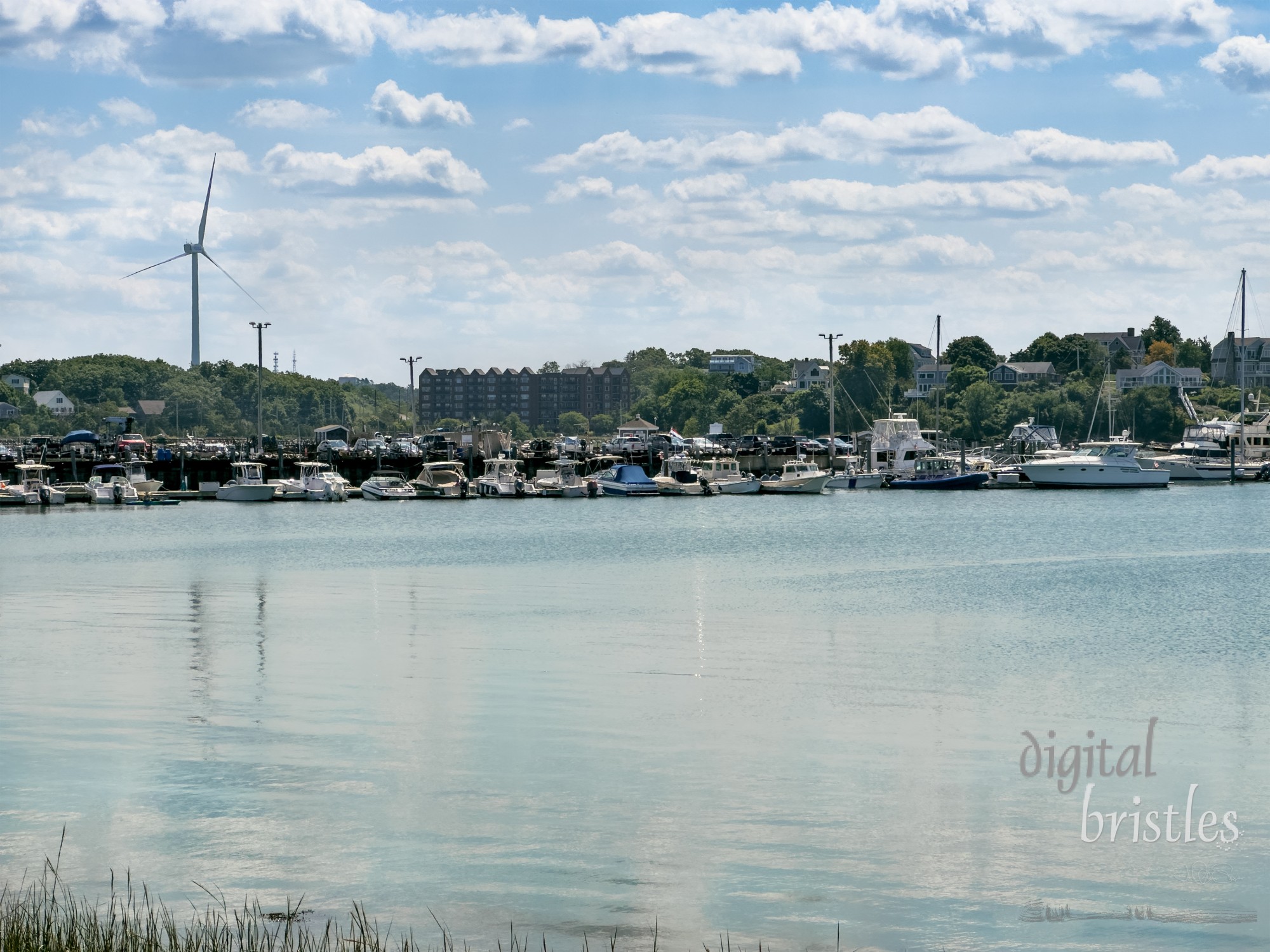 Marina in the basin by Nantasket Beach with the Hull Wind 2 turbine  (inoperable) rising above the trees