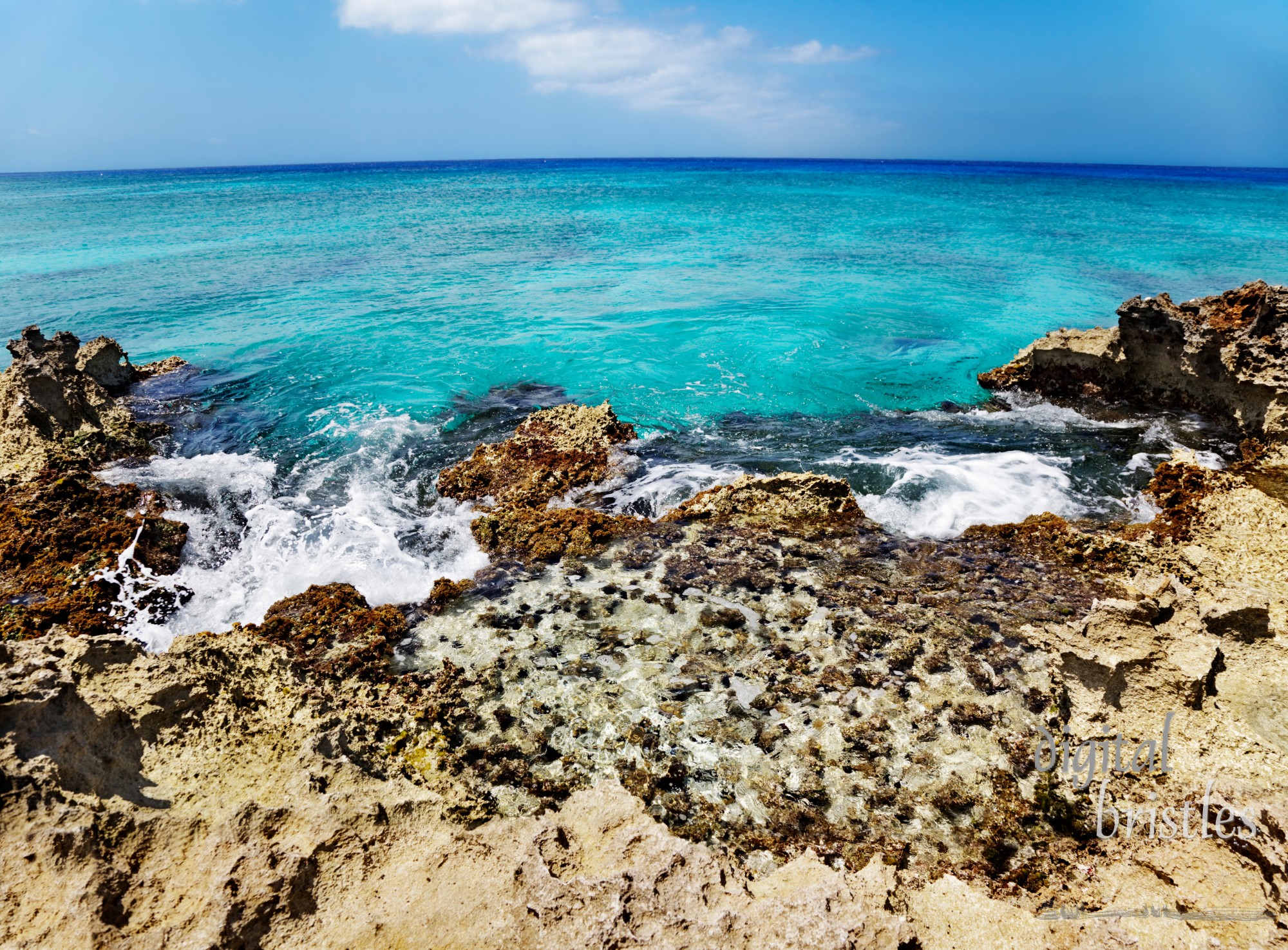 Tide pool overlooking the reef-edged coast of Grand Cayman (Smith Cove). Slight curve on the horizon