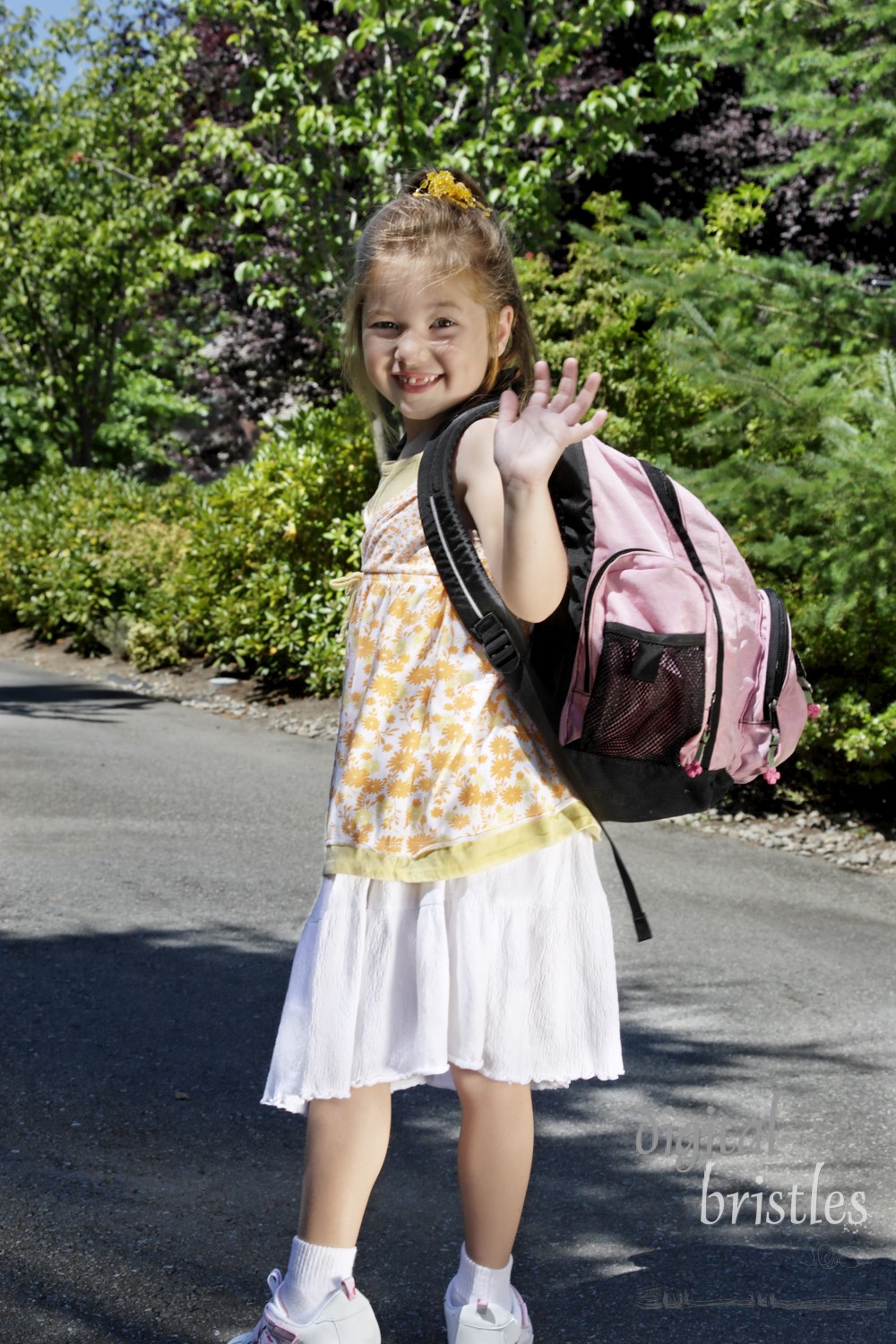 Young girl turning to wave goodbye as she heads for school