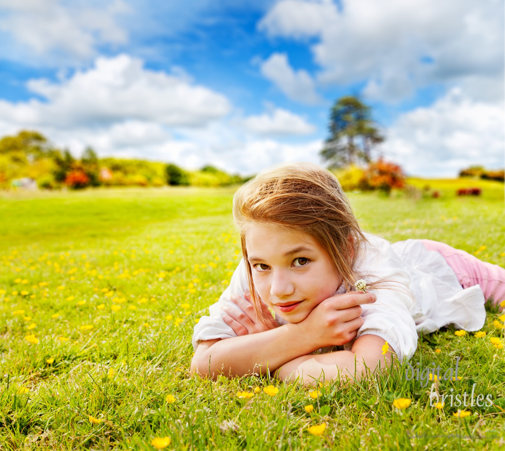 Young girl relaxing in the grass in a sunny field