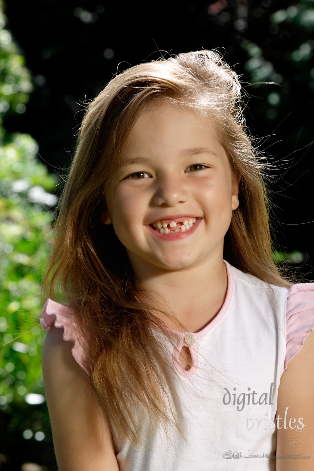 Young girl shows off her missing teeth with a huge, happy smile