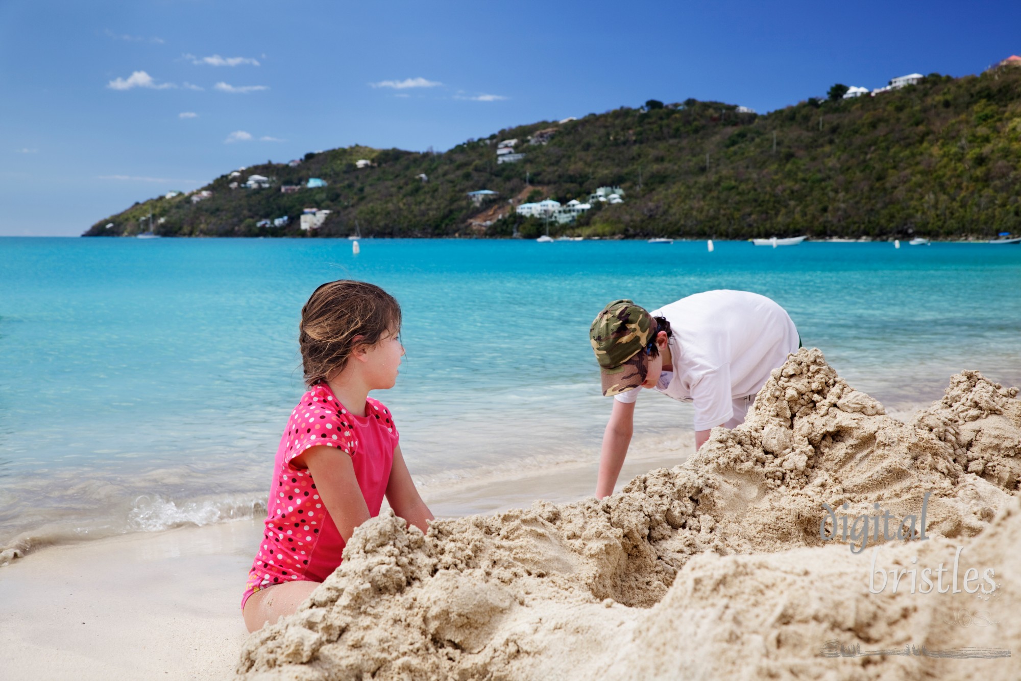 Brother & sister build sandcastles on the beach