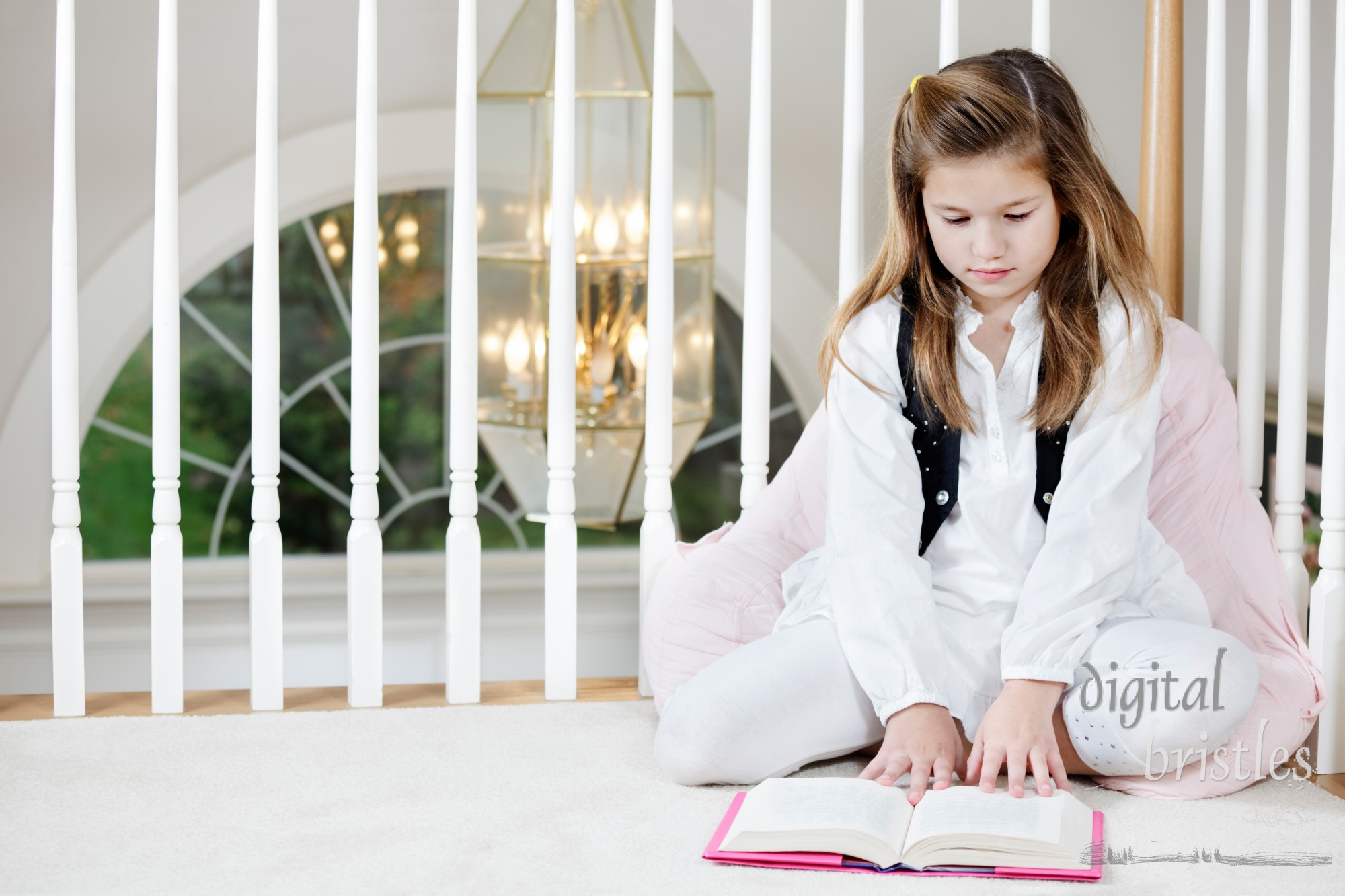 Young girl sits on the floor reading