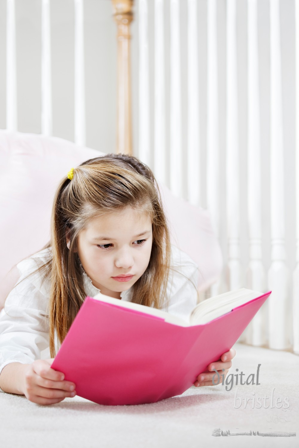 Young girl lying on the floor concentrating on her reading