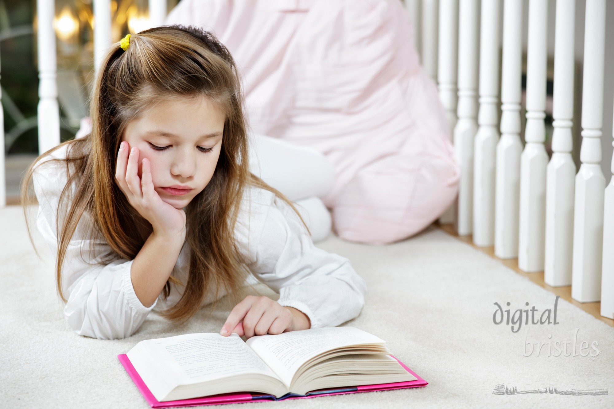 Young girl lying on the floor reading