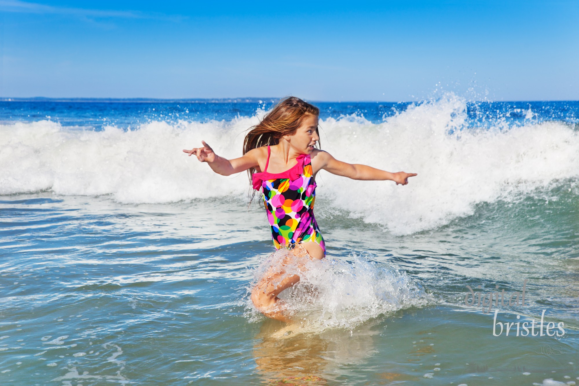 Young girl turning to run from an incoming wave