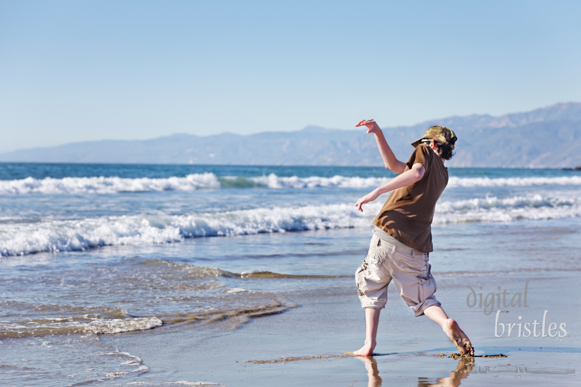 Teenage boy skimming stones at the beach