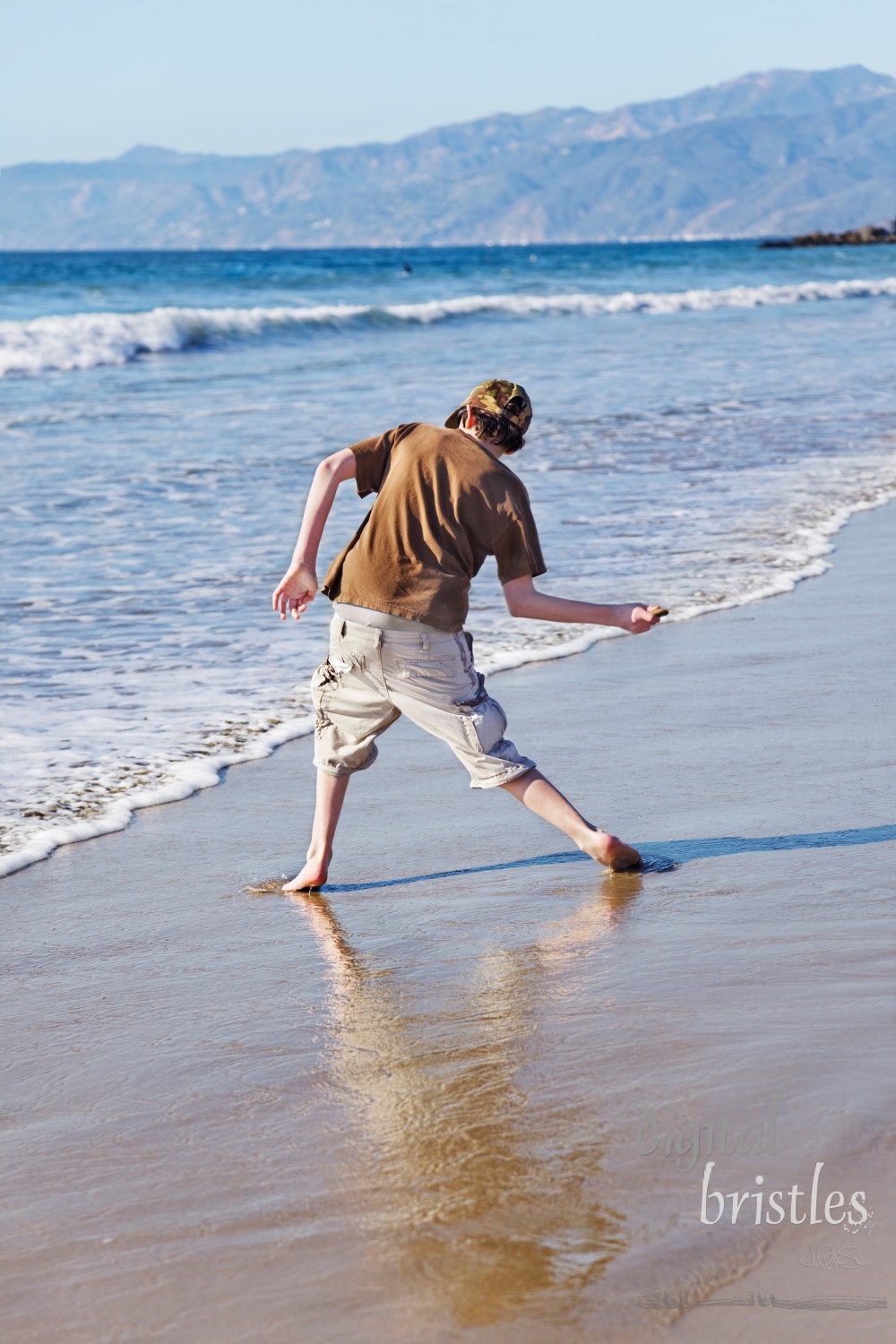 Teenage boy skimming stones at the beach