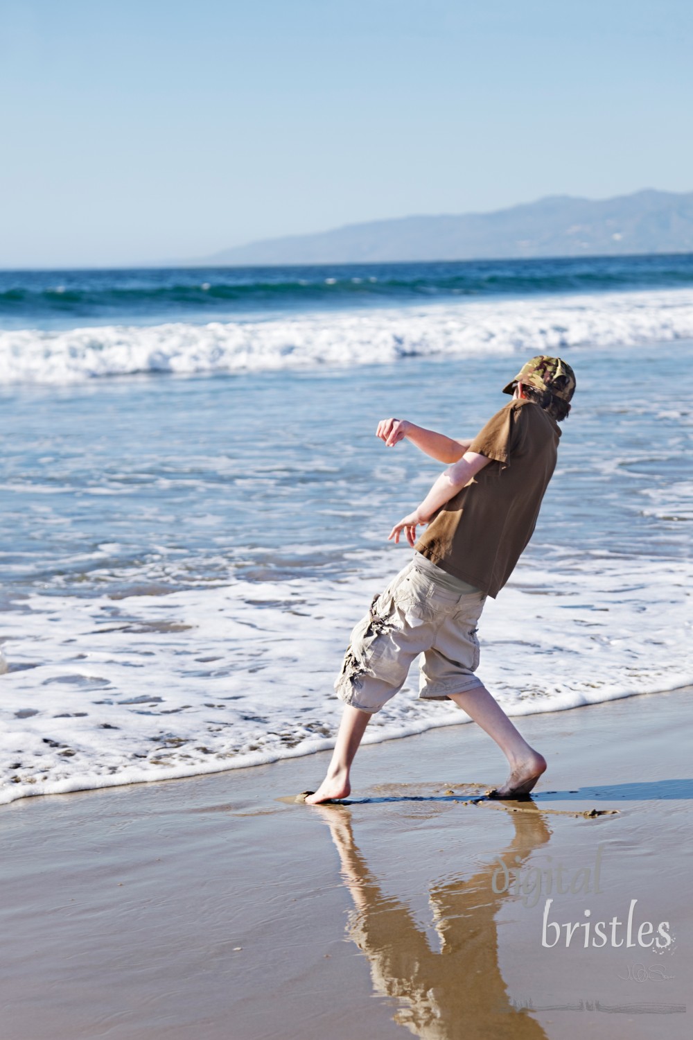 Teenage boy skimming stones at the beach