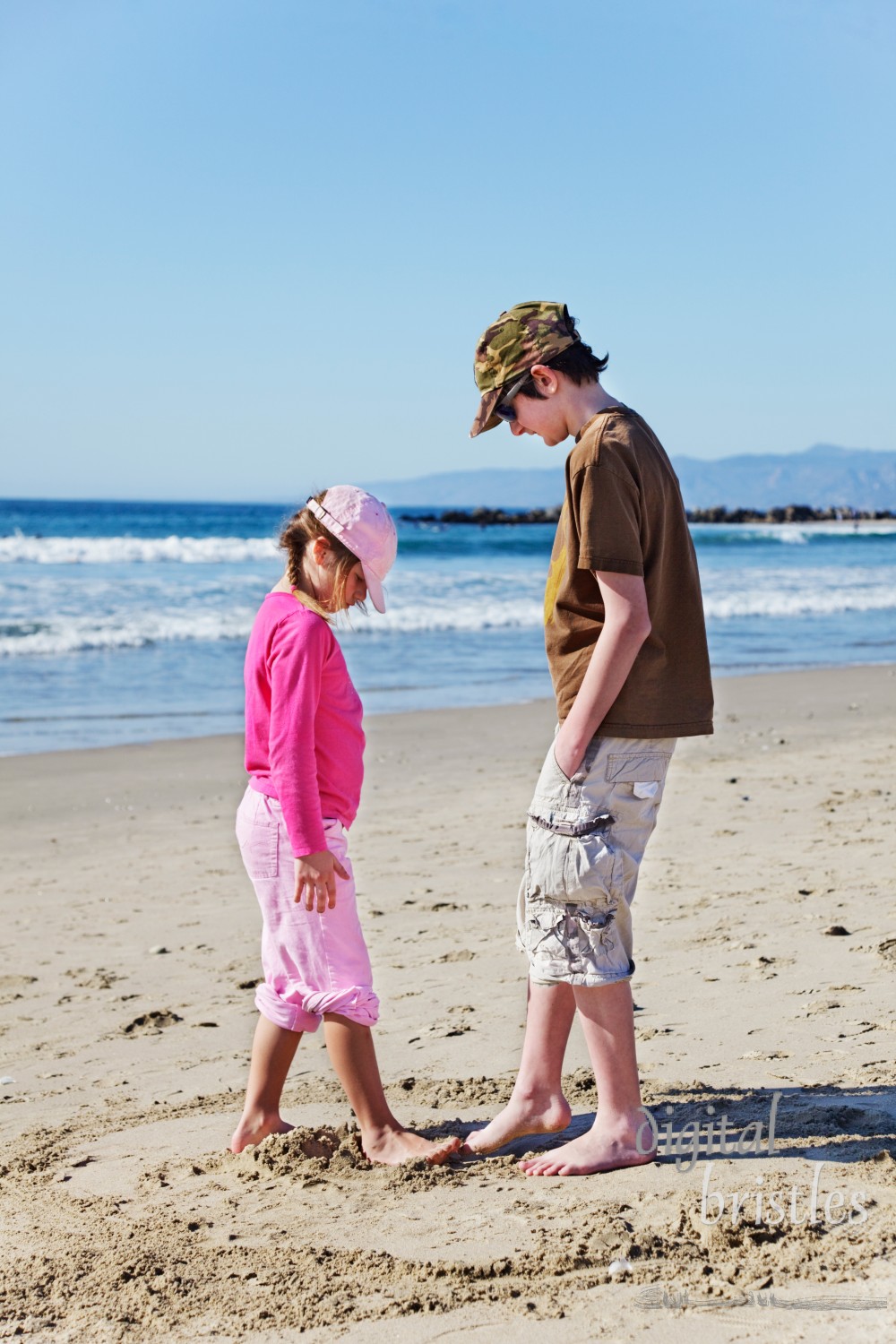 Brother & sister's impromptu sand game at the beach