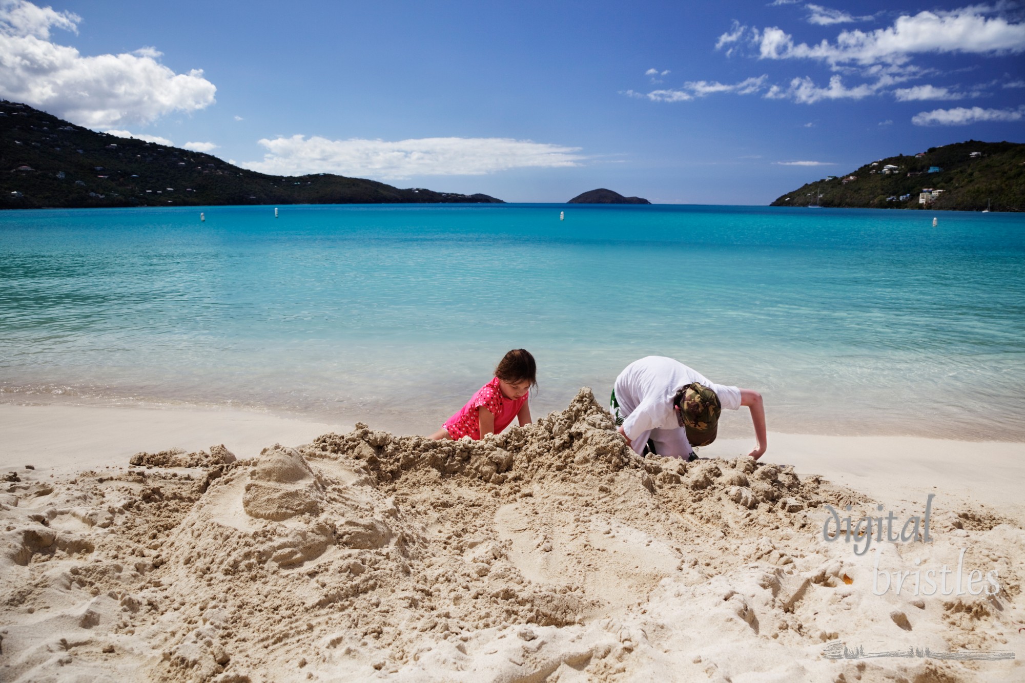 Brother & sister build sandcastles on the beach