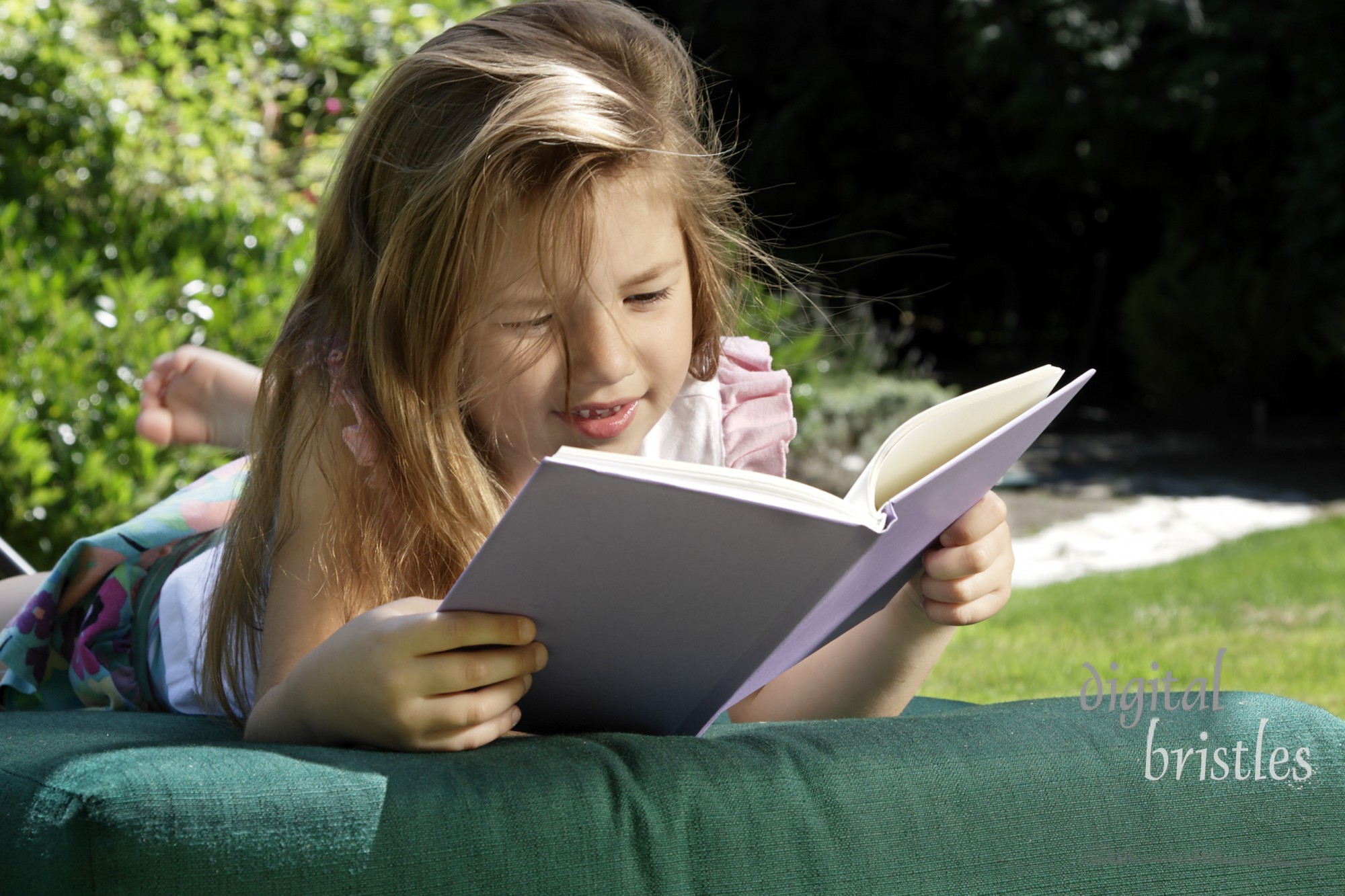 Young girl relaxing outside with a good book