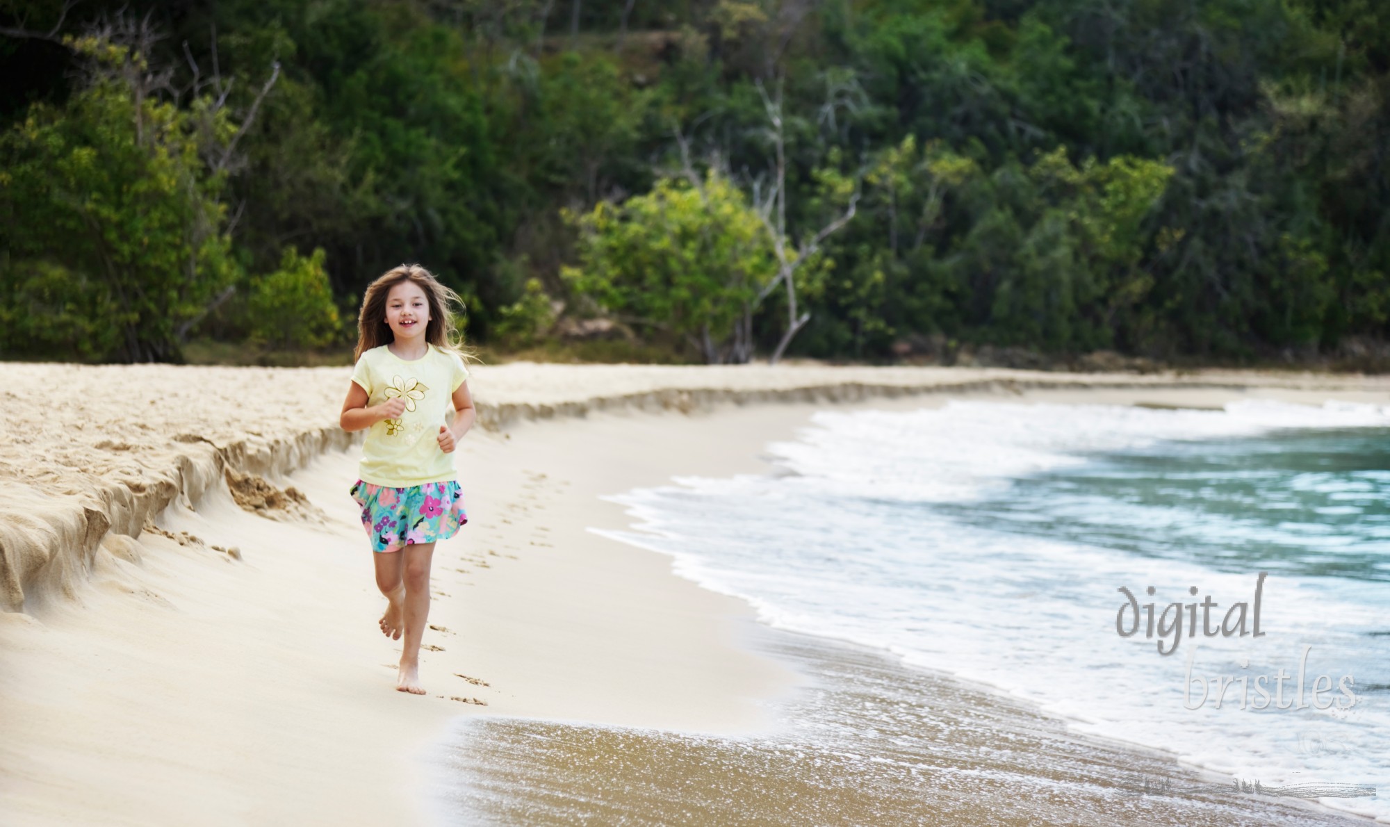 Young girl running along the beach at water's edge