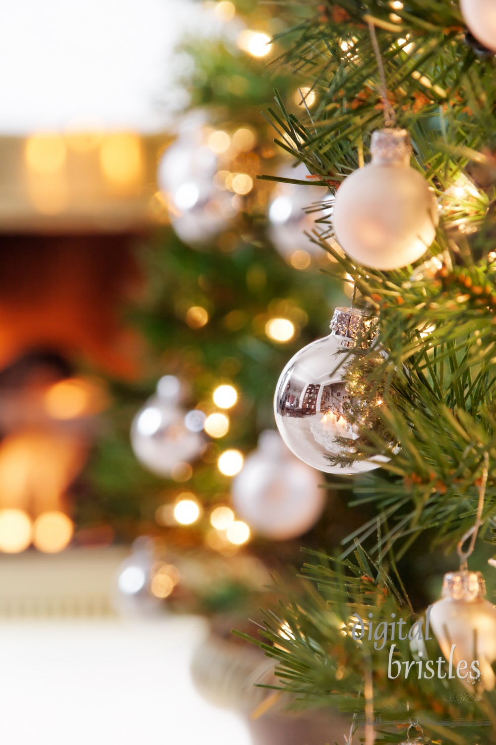 Glittering silver and white Christmas tree decorations by a warm fire