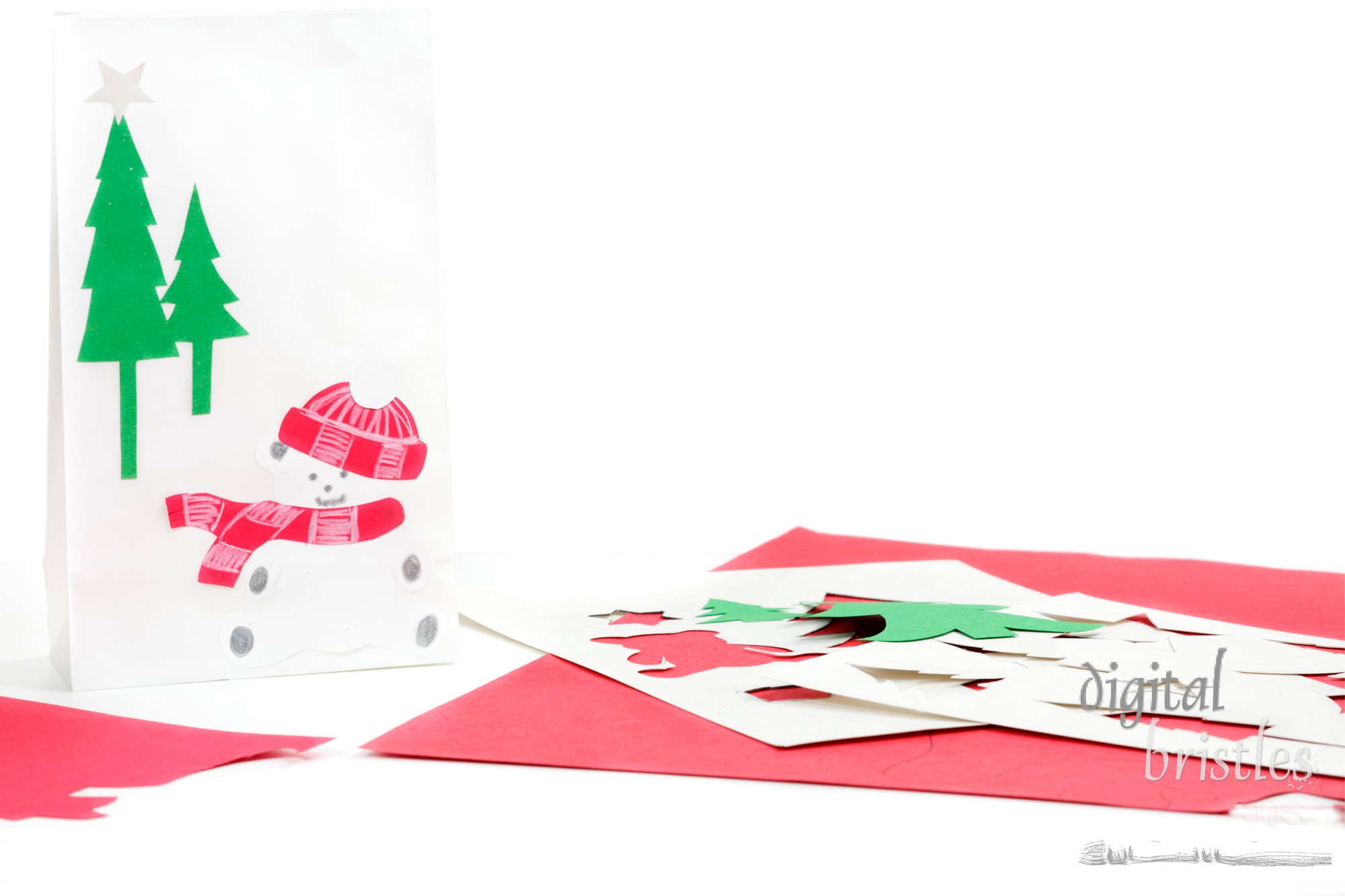 Construction paper, bag, and stencils to make Christmas gift bags