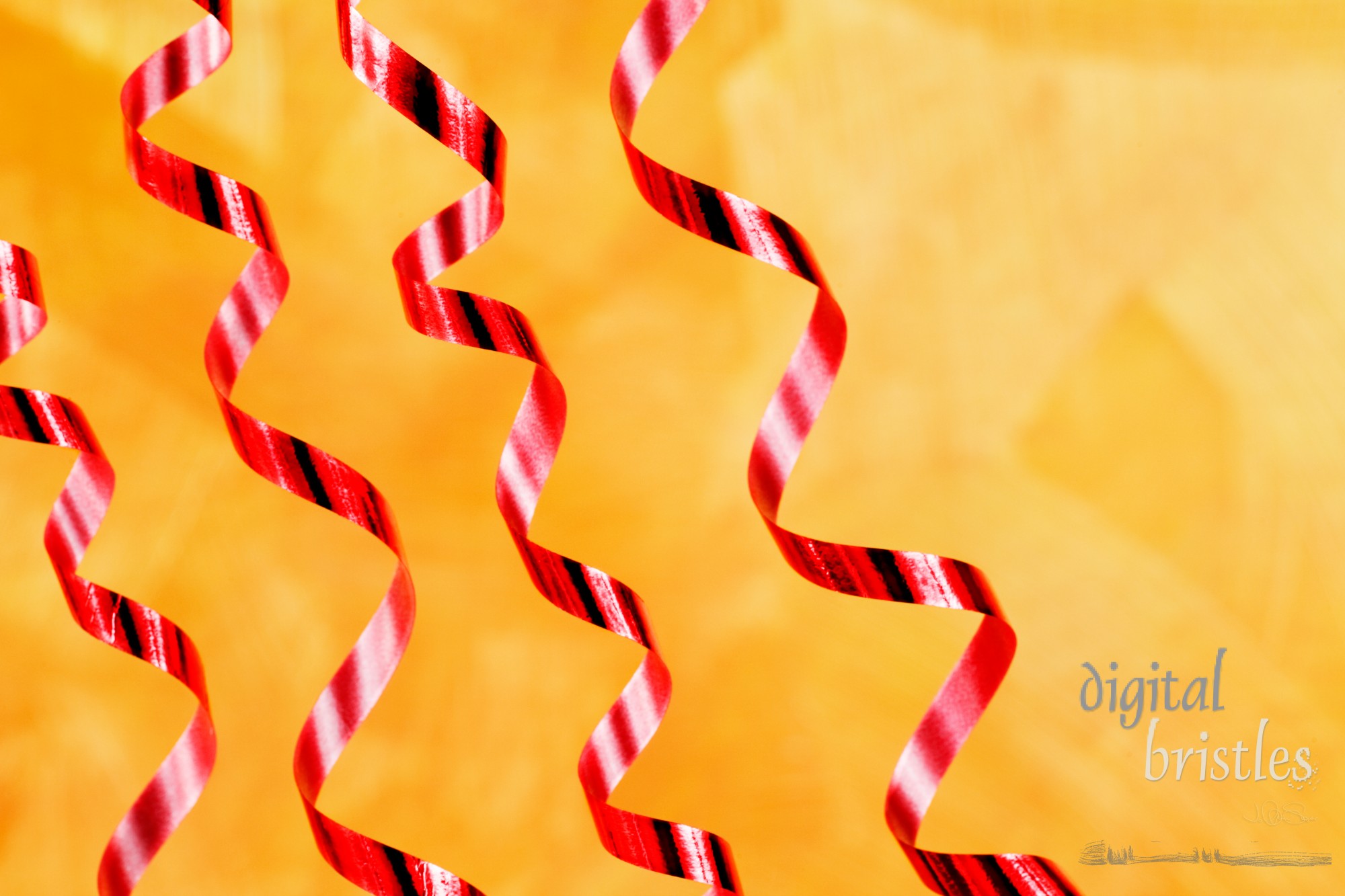 Shiny red curling ribbon over a gold hand painted background