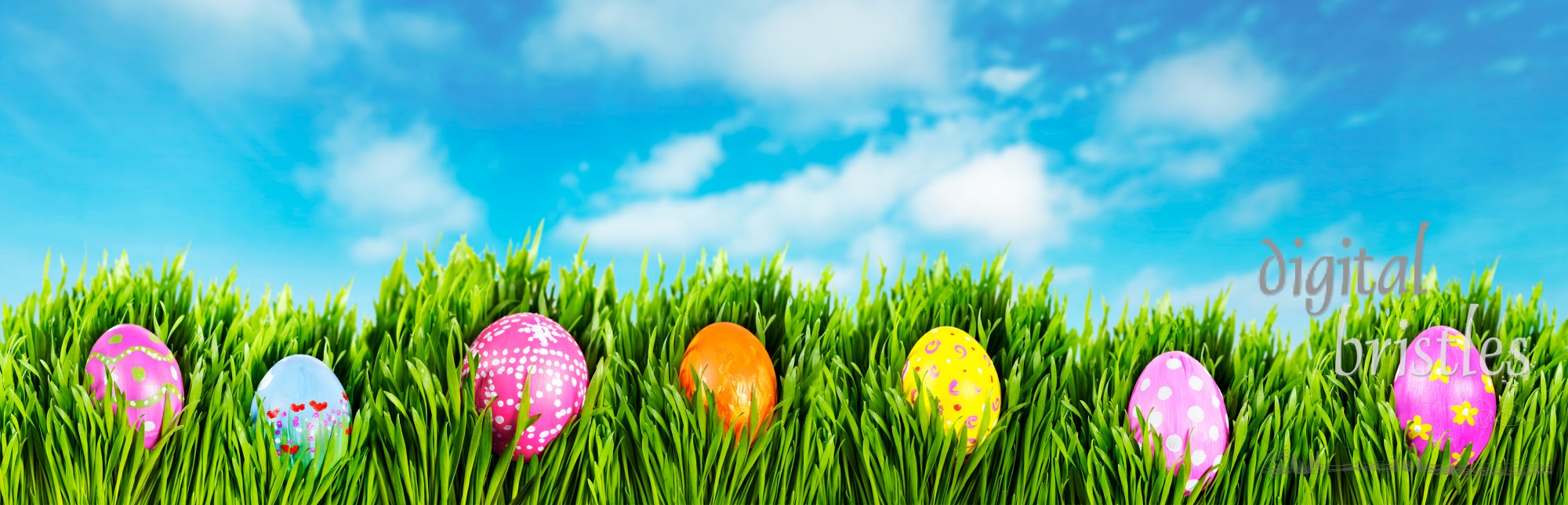 Hand painted easter eggs nestled in grass on a sunny Spring morning