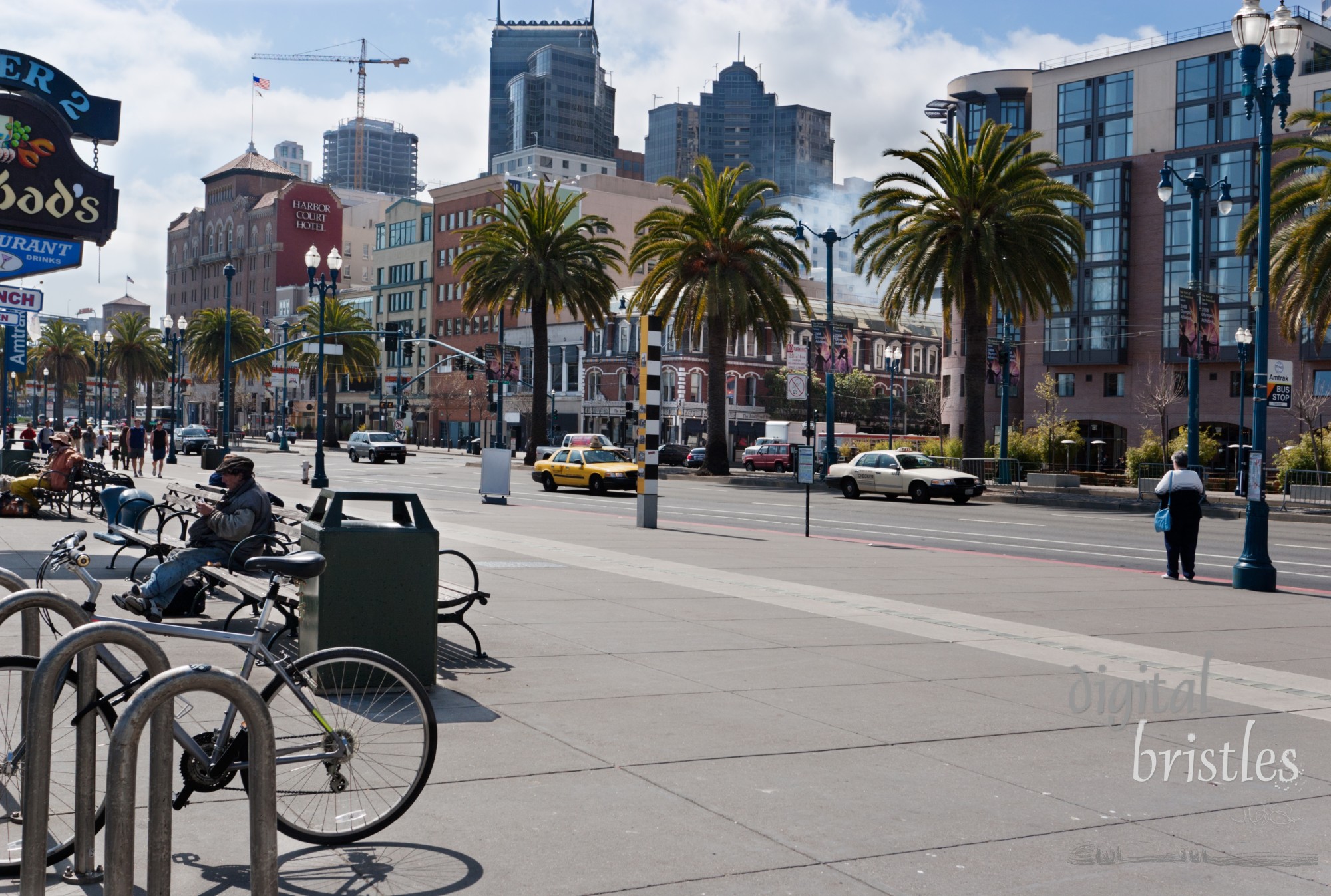 Mix of tourists and residents on on a sunny morning on The Embarcadero. Taken looking toward the Oakland Bay Bridge from near the Ferry Building