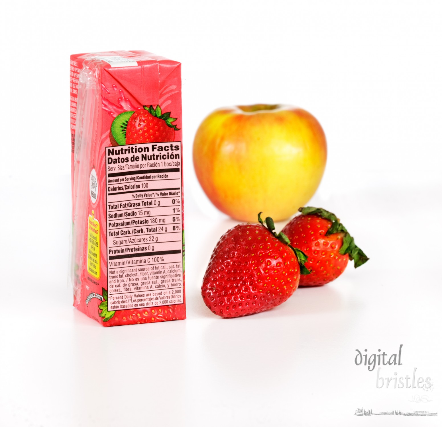 Fruit juice box or fresh fruit for a snack. Kiwi Strawberry Juicy Juice box with nutrition panel visible. Fresh apple and strawberries as the whole fruit alternative. Juicy Juice is a trademark of Société des Produits Nestlé S.A