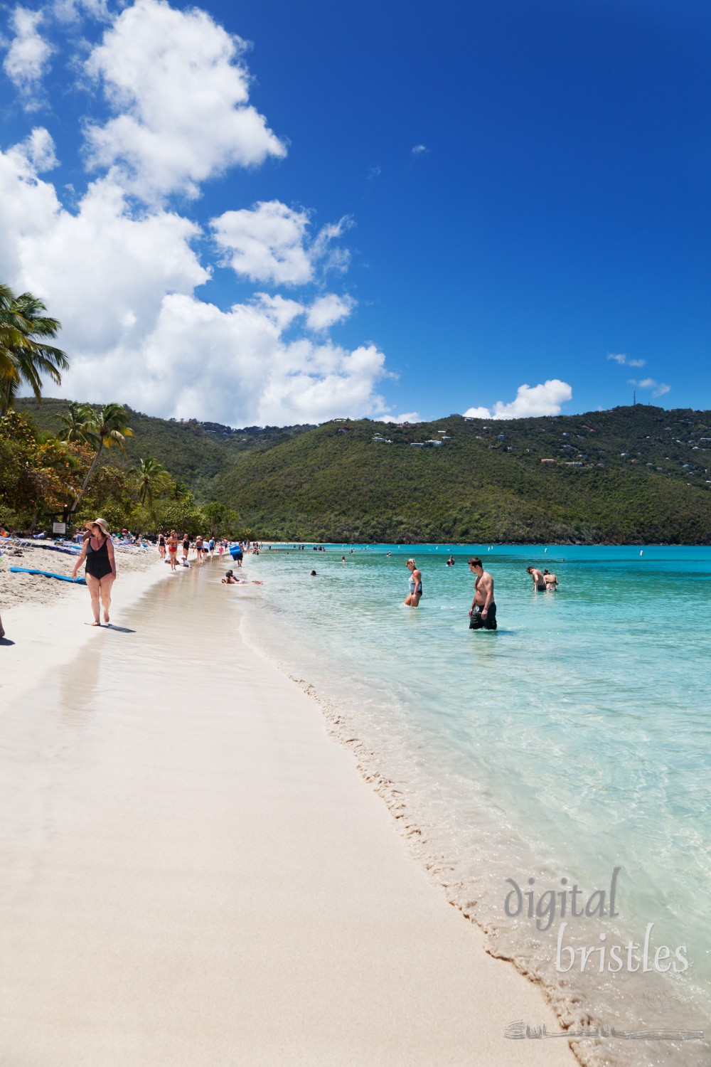 Swimmers and sunbathers enjoy the protected waters and long soft white sand beach at Magens Bay. The beautiful one mile beach is a public park and was donated to the people of the Virgin Islands by Arthur Fairchild. Shot with a polarizing filter.