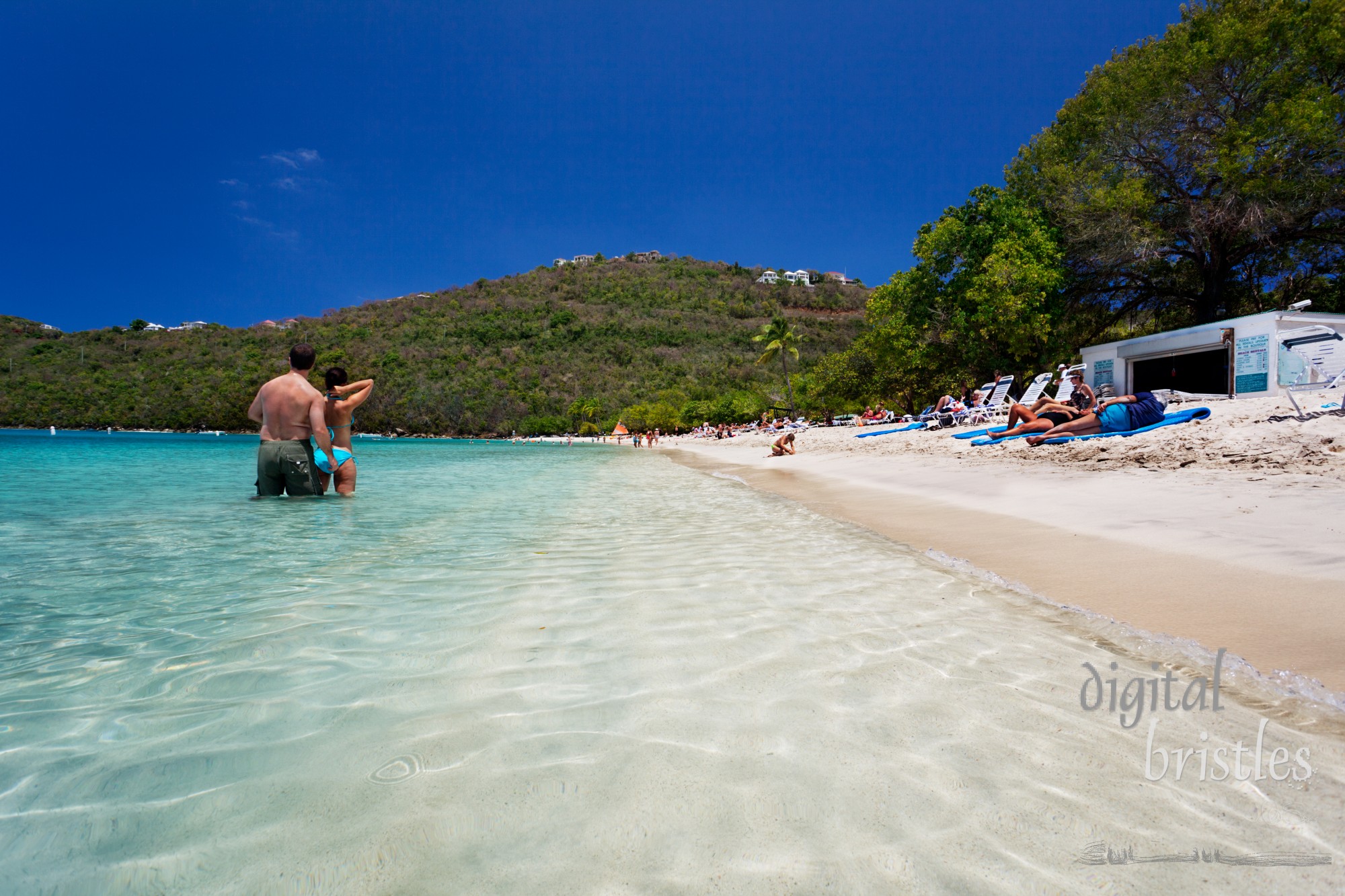 Swimmers and sunbathers enjoy the protected waters and long soft white sand beach at Magens Bay. The beautiful one mile beach is a public park and was donated to the people of the Virgin Islands by Arthur Fairchild. Shot with a polarizing filter.