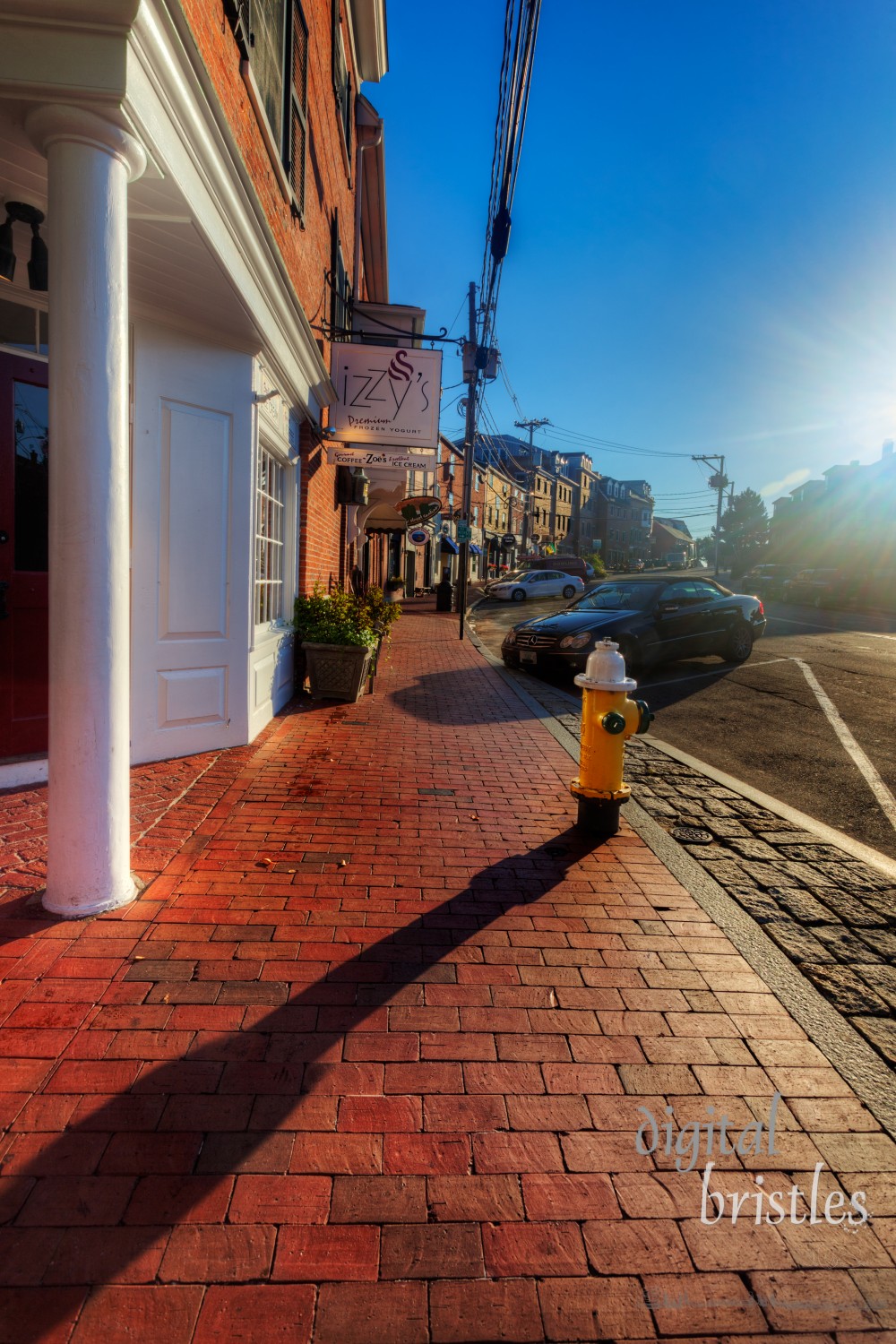 Aug 22, 2012, Portsmouth, NH. Bow Street shops bathed in bright early morning sunshine. The street is packed with tourists later in the day but is deserted right after sunrise. Bow Street connects Portsmouth's two primary waterfront area, Ceres Street andPrescott Park. Its brick warehouse buildings were constructed after the 1806 fire.