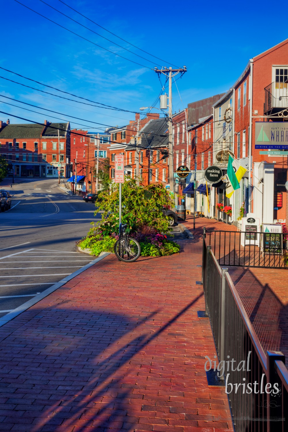 Aug 22, 2012, Portsmouth, NH. Bow Street looking downhill towards Market Street. Shops and restaurants are lit by early morning sunshine. The street busy later in the day but is deserted right after sunrise. Bow Street connects Portsmouth's two primary waterfront area, Ceres Street and Prescott Park.