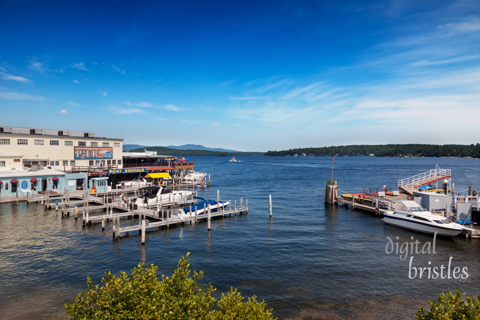 Weirs Beach, Laconia, NH, Aug 19, 2013. Anthony's Restaurant on the Winnipesaukee Pier overlooks the departing floating post office Sophie C on a sunny summer afternoon on Lake Winnipesaukee, New Hampshire