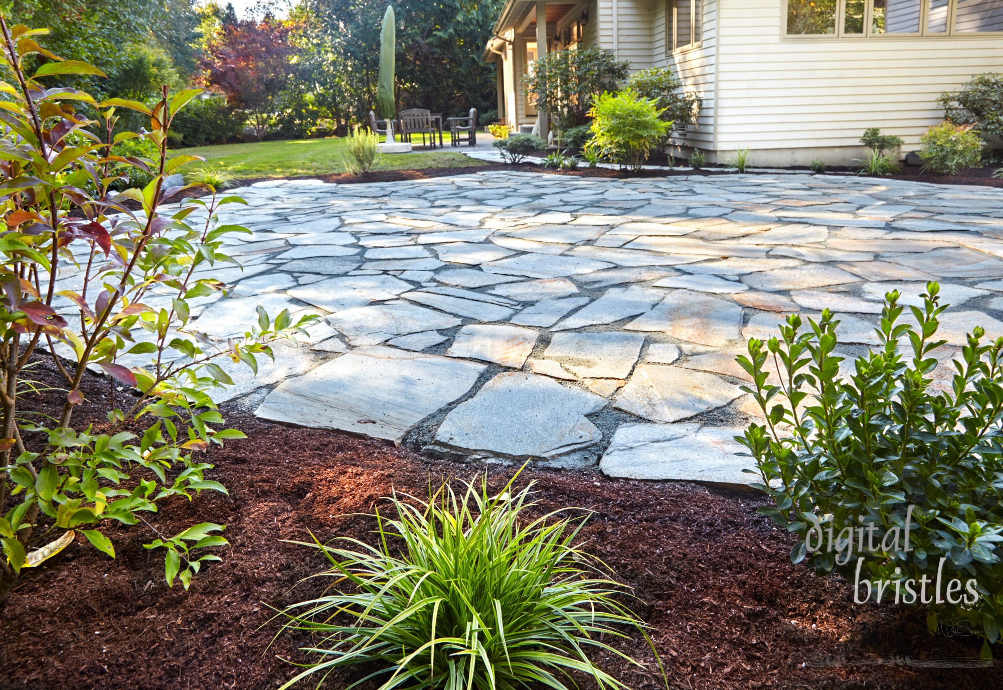 Stone patio compleete with new flower beds and shrubs on all sides