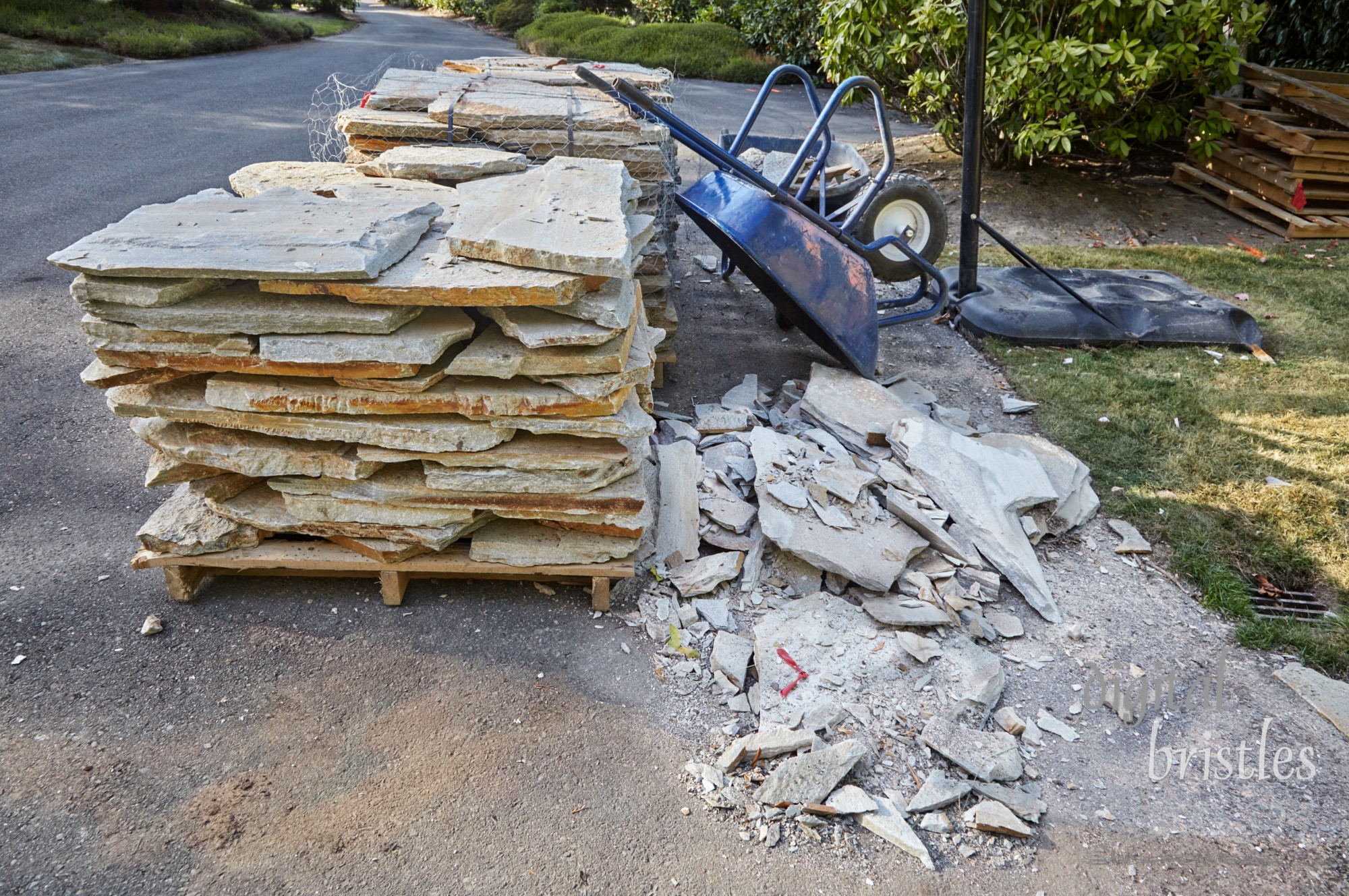 Pallets of paving stones delivered in driveway for patio project