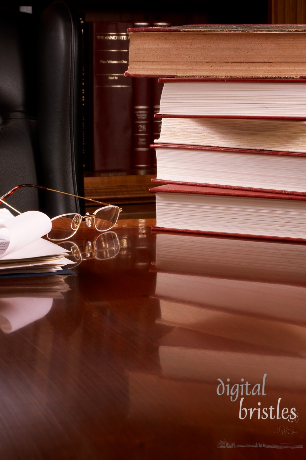 Stack of books reflected in wooden desk