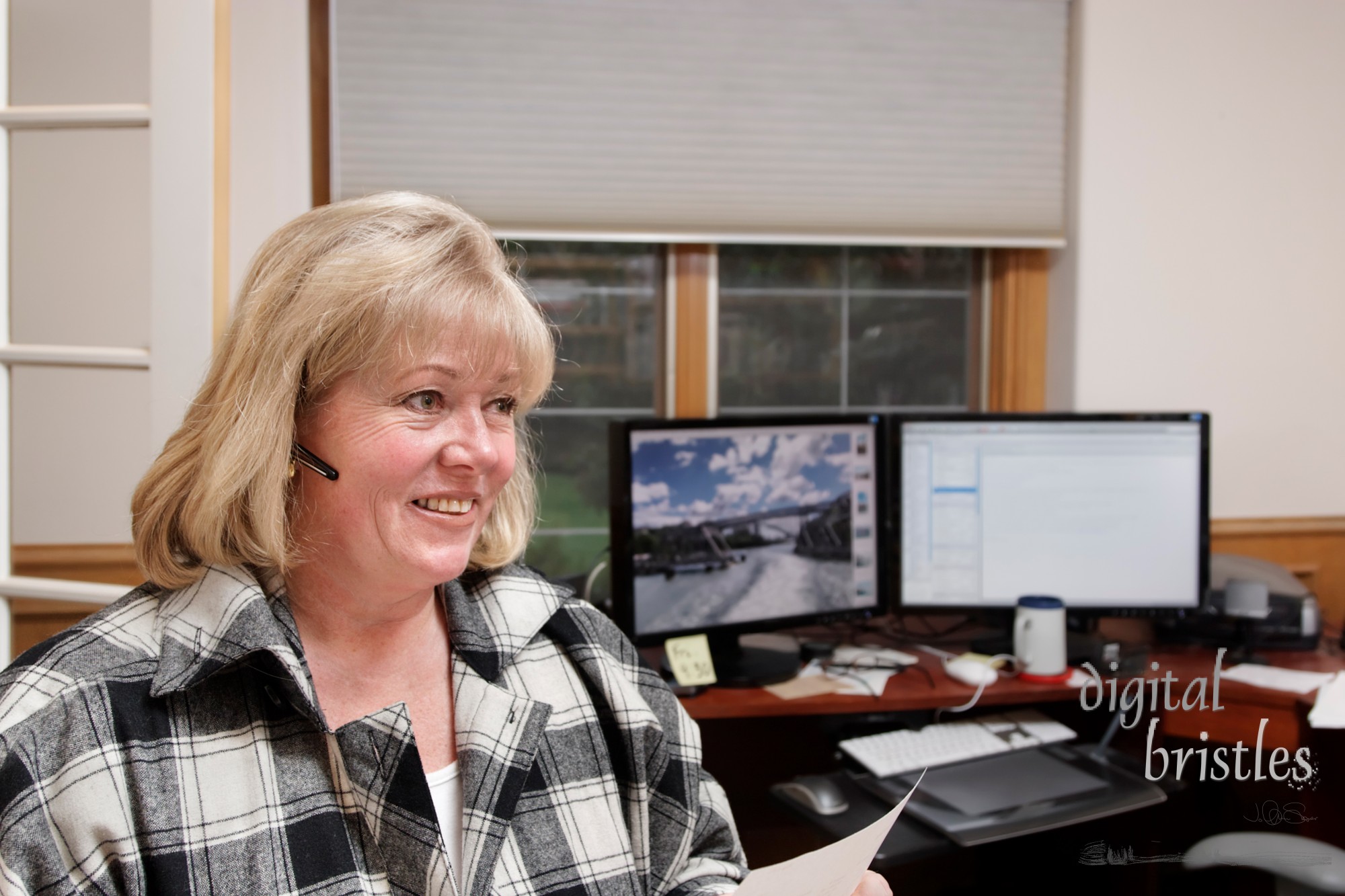 Mature woman smiles while on the phone in a home office