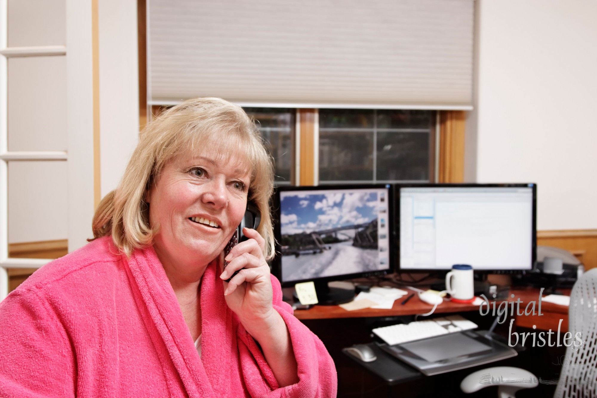 Mature woman on the phone in a home office, not yet dressed